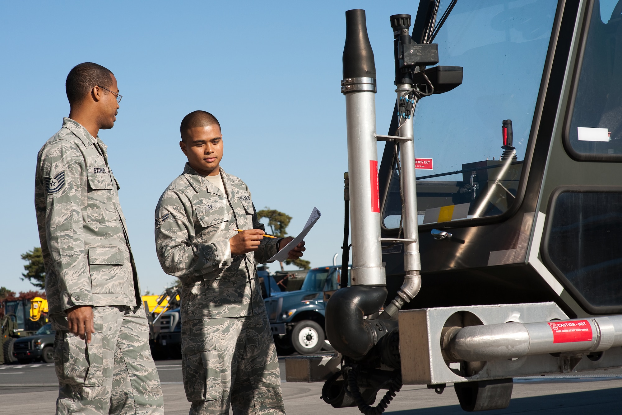 YOKOT AIR BASE, Japan -- Airman 1st Class Christopher Sy (right), 374th Logistics Readiness Squadron, inspects a global de-icer so that it is prepared, if needed this winter season, here Dec. 15. Vehicle maintainers from the 374 LRS maintain over 1200 vehicles in Yokota. (U.S. Air Force photo/Osakabe Yasuo)