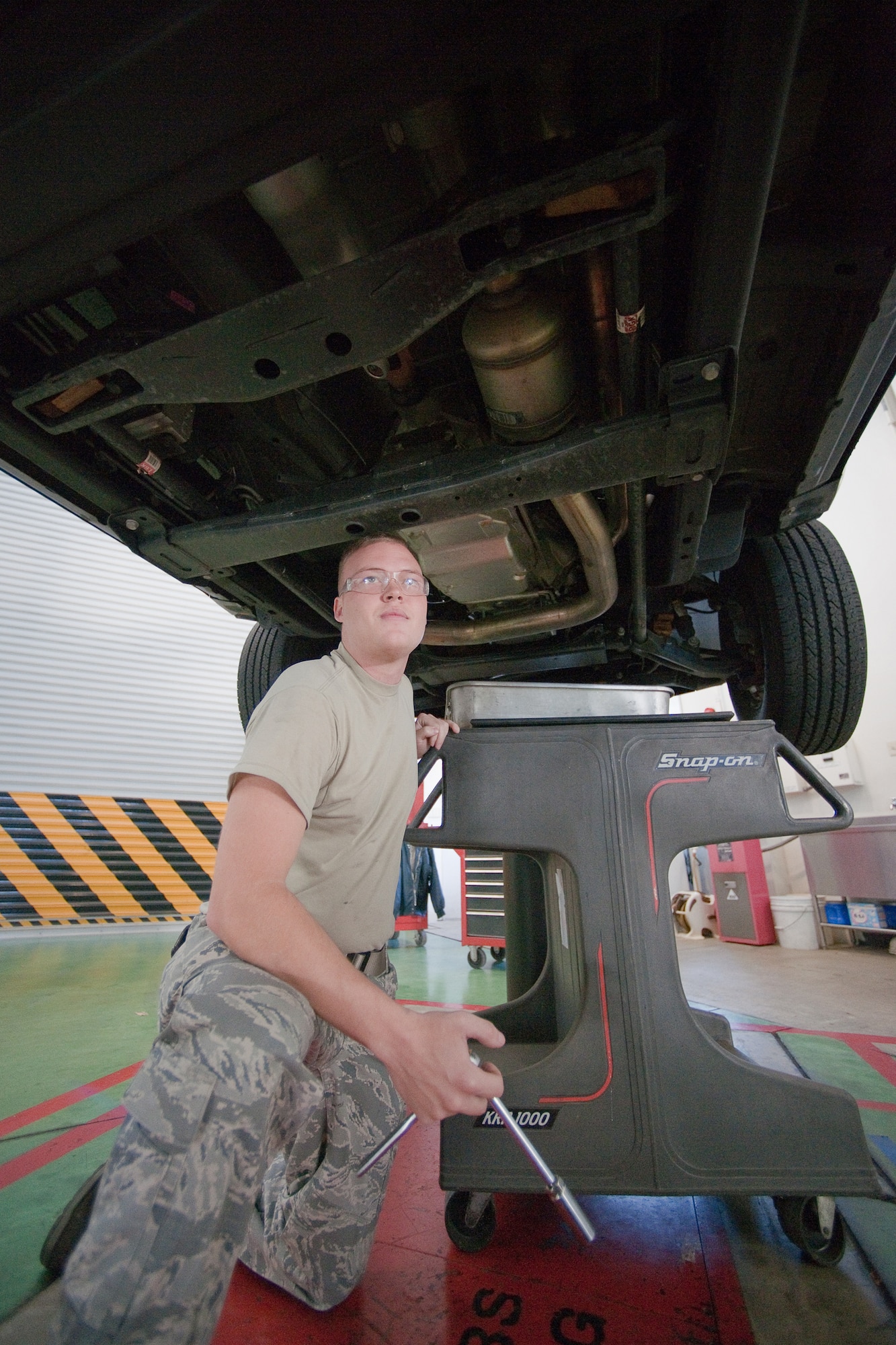 YOKOTA AIR BASE, Japan -- Airman 1st Class Martin Trost, 374th Logistics Readiness Squadron, performs monthly maintenance on a government vehicle here Dec. 15. Vehicle maintainers from the 374 LRS maintain over 1200 vehicles in Yokota. (U.S. Air Force photo/Osakabe Yasuo)