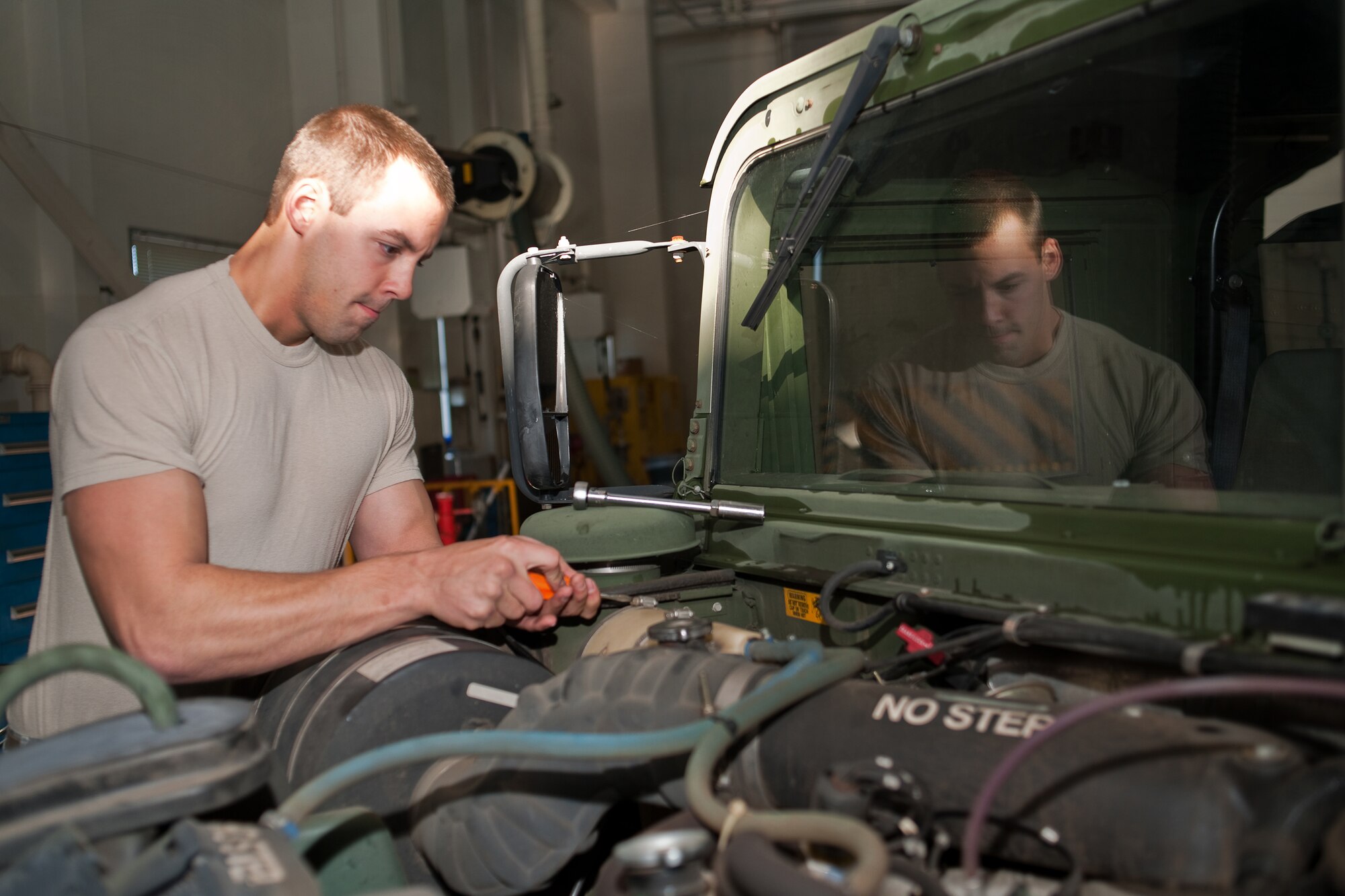 YOKOTA AIR BASE, Japan -- Airman 1st Class James Beck, 374th Logistics Readiness Squadron, performs monthly maintenance on a humvee here Dec. 15.  Vehicle maintainers from the 374th LRS maintain over 1200 vehicles at Yokota. (U.S. Air Force photo/Osakabe Yasuo)