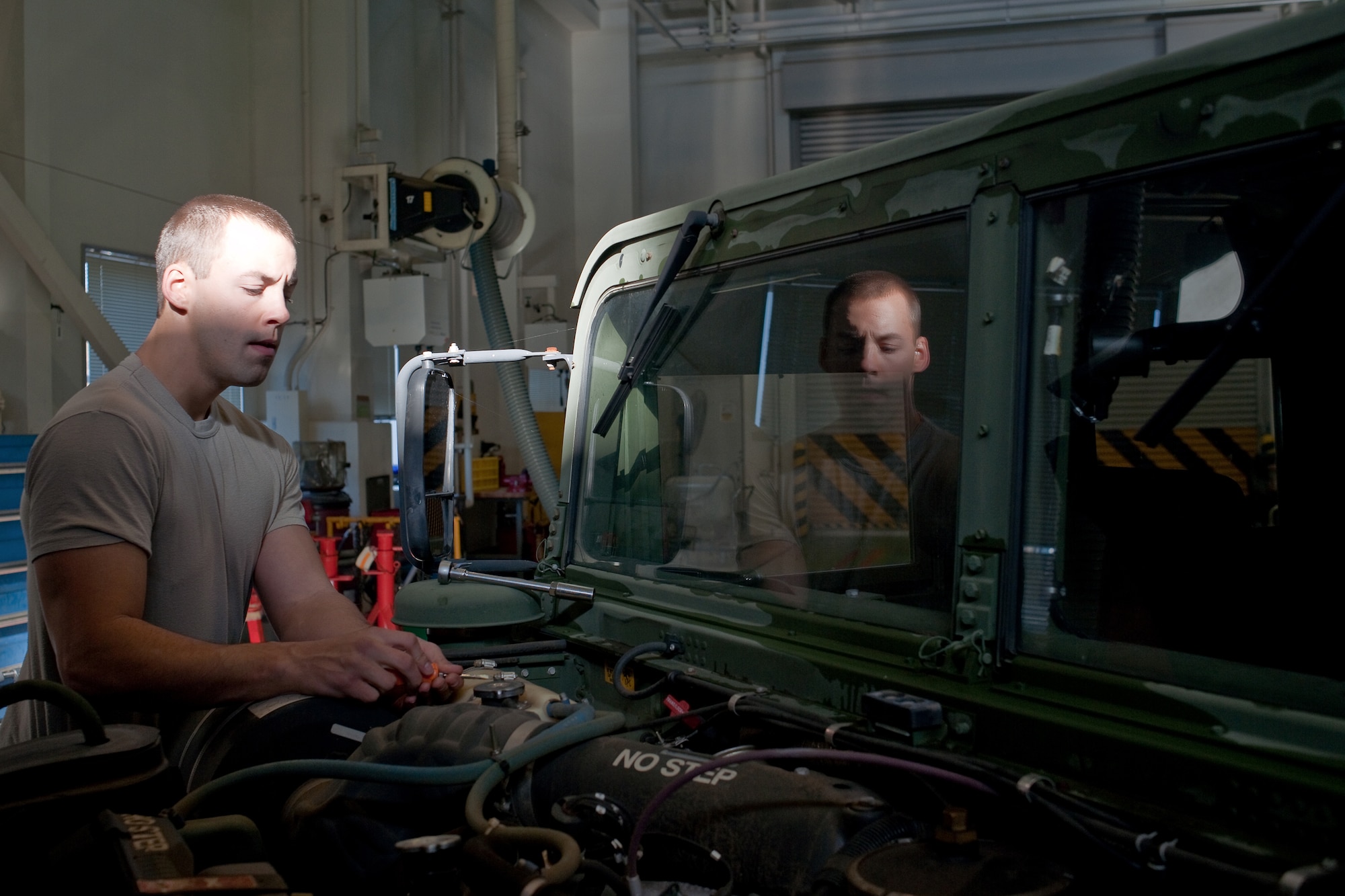 YOKOTA AIR BASE, Japan -- Airman 1st Class James Beck, 374th Logistics Readiness Squadron, performs monthly maintenance on a humvee here Dec. 15.  Vehicle maintainers from the 374 LRS maintain over 1200 vehicles at Yokota. (U.S. Air Force photo/Osakabe Yasuo)