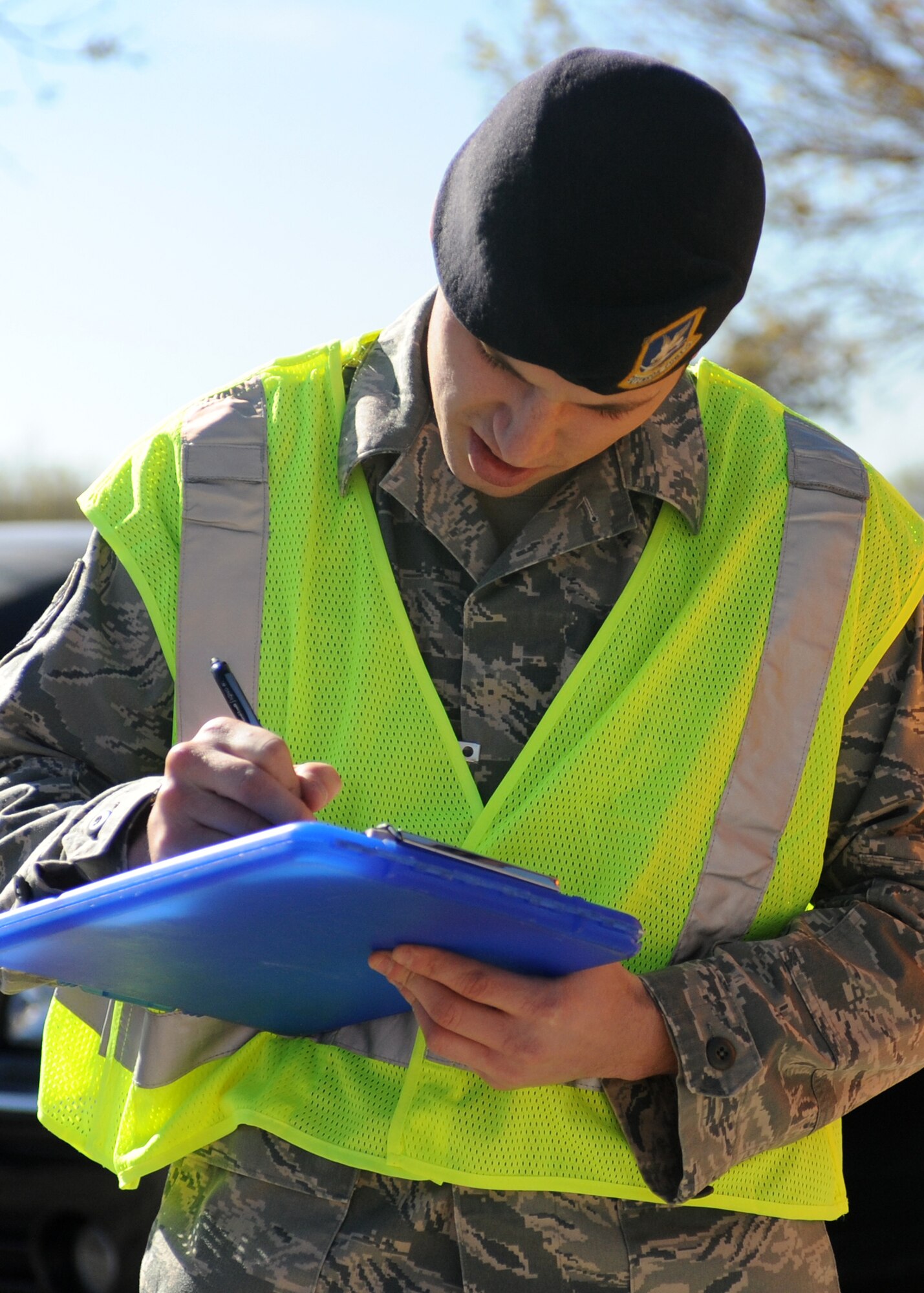 DYESS AIR FORCE BASE, Texas -- Staff Sgt. Daniel Reagan, 7th Security Forces Squadron, writes a traffic citation, while traffic was reduced to screen for individuals not wearing seatbelts and illegally using cellular phones Dec. 14, here.  Using a cellular phone while driving increases the chances of getting into an accident by 400 percent and failure to wear a seat belt contributes to more fatalities than any other single traffic safety-related behavior. (U.S. Air Force photo/Senior Airman Jenifer H. Calhoun)