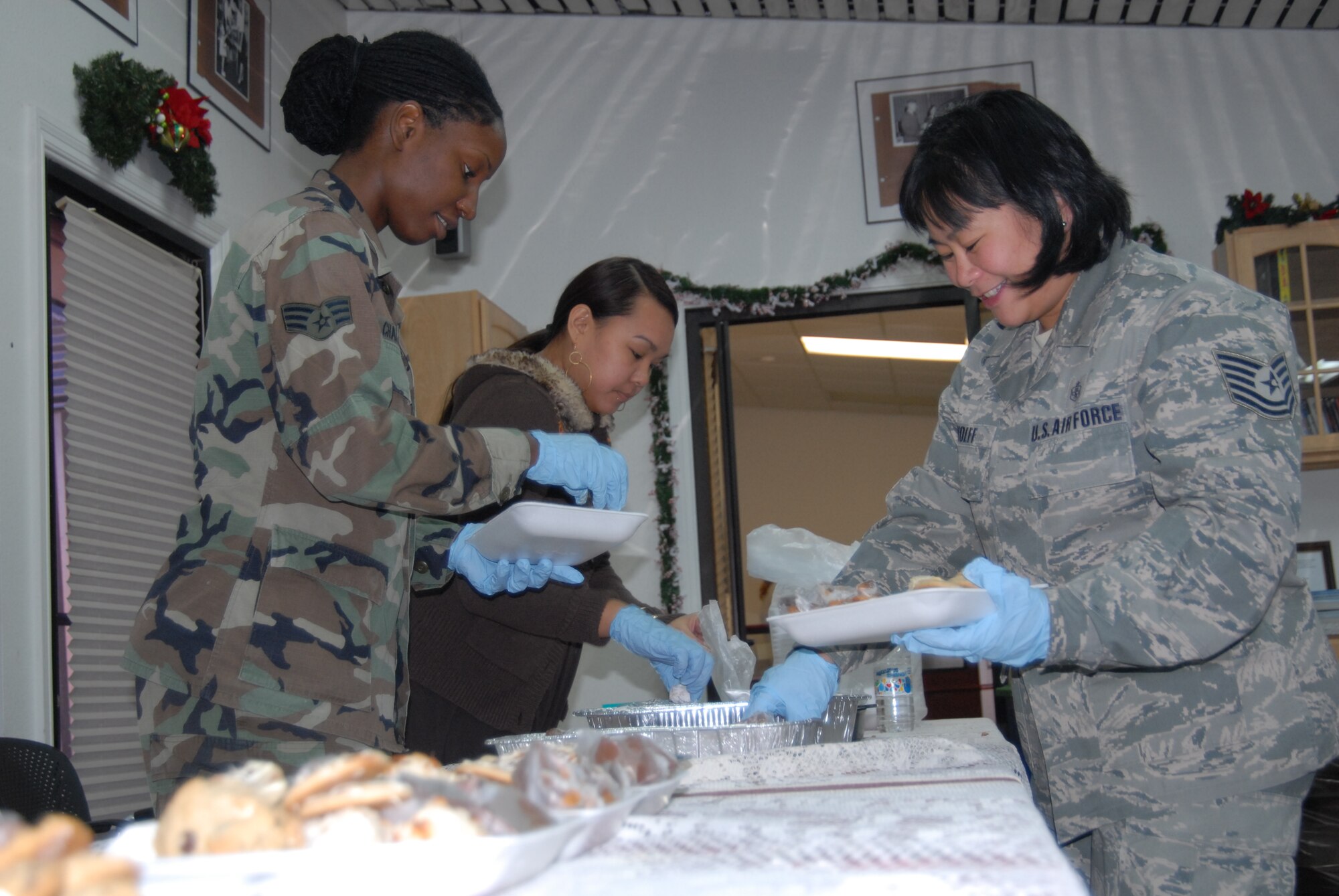 Tech. Sgt. Michelle Wolff and Senior Airman Melissa Charles, both from the 95th Aerospace Medicine Squadron, volunteer their time to help sort and package homemade baked goods as part of the Airman and Family Readiness Center’s annual Dorm Dweller’s Cookie Drive, Dec. 8. The event was organized to bring a sense of home during the holidays to Airmen who live in the dorms. (Air Force photo by Kate Blais)