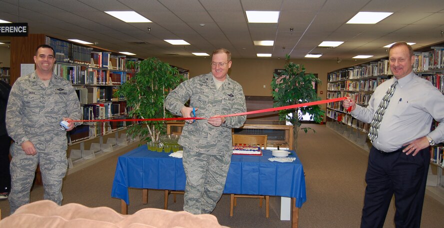 MINOT AIR FORCE BASE, N.D. -- Col. Doug Cox, 5th Bomb Wing commander, cuts the ribbon during the grand opening of the newly remodeled base library here Dec. 2. (Photo courtesy/Francis X. Deignan Education and Library Center)