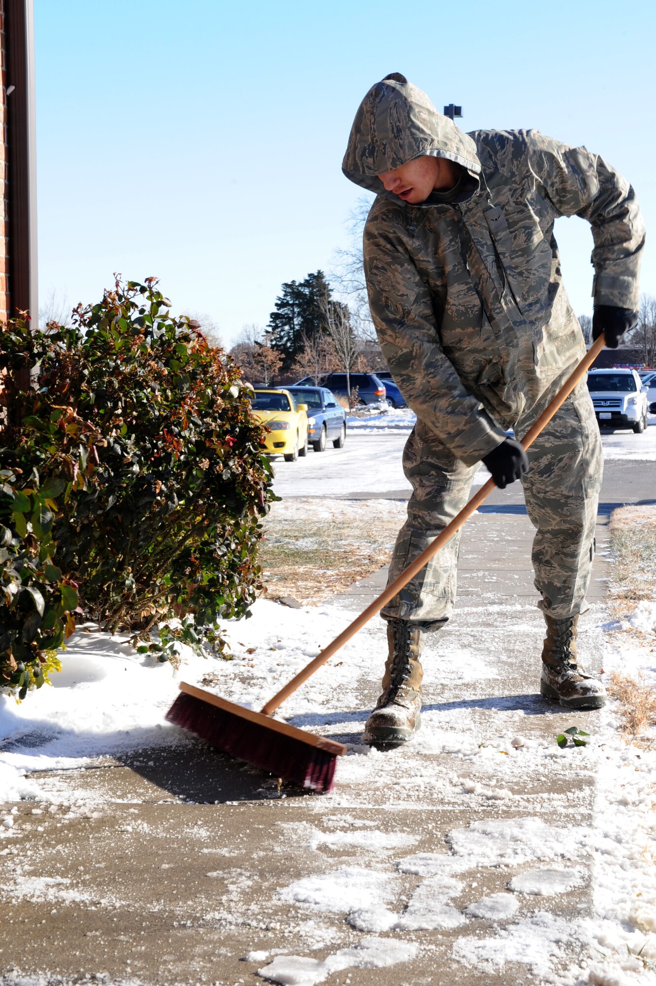Airman Jesus Avila III, 375th Logistics Readiness Squadron Petroleum, Oils and Lubricants Flight, clears snow from the walkways to their building Dec. 13, 2010, at Scott Air Force Base, Ill. Scott turned into a “winter wonderland” when it received its first snow of the winter season Dec. 12. (U.S. Air Force photo/Staff Sgt. Brian J. Valencia)