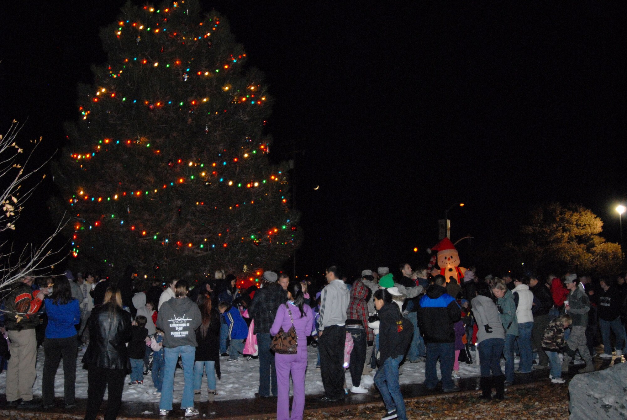 People showed up in droves for this year's annual holiday tree lighting Dec. 7. The night also featured tons of machine-made snow for children of all ages to play in. Santa Claus and a fire engine from Edwards Fire Department also made appearances for the delighted audience. (Air Force photo by Kenji Thuloweit)