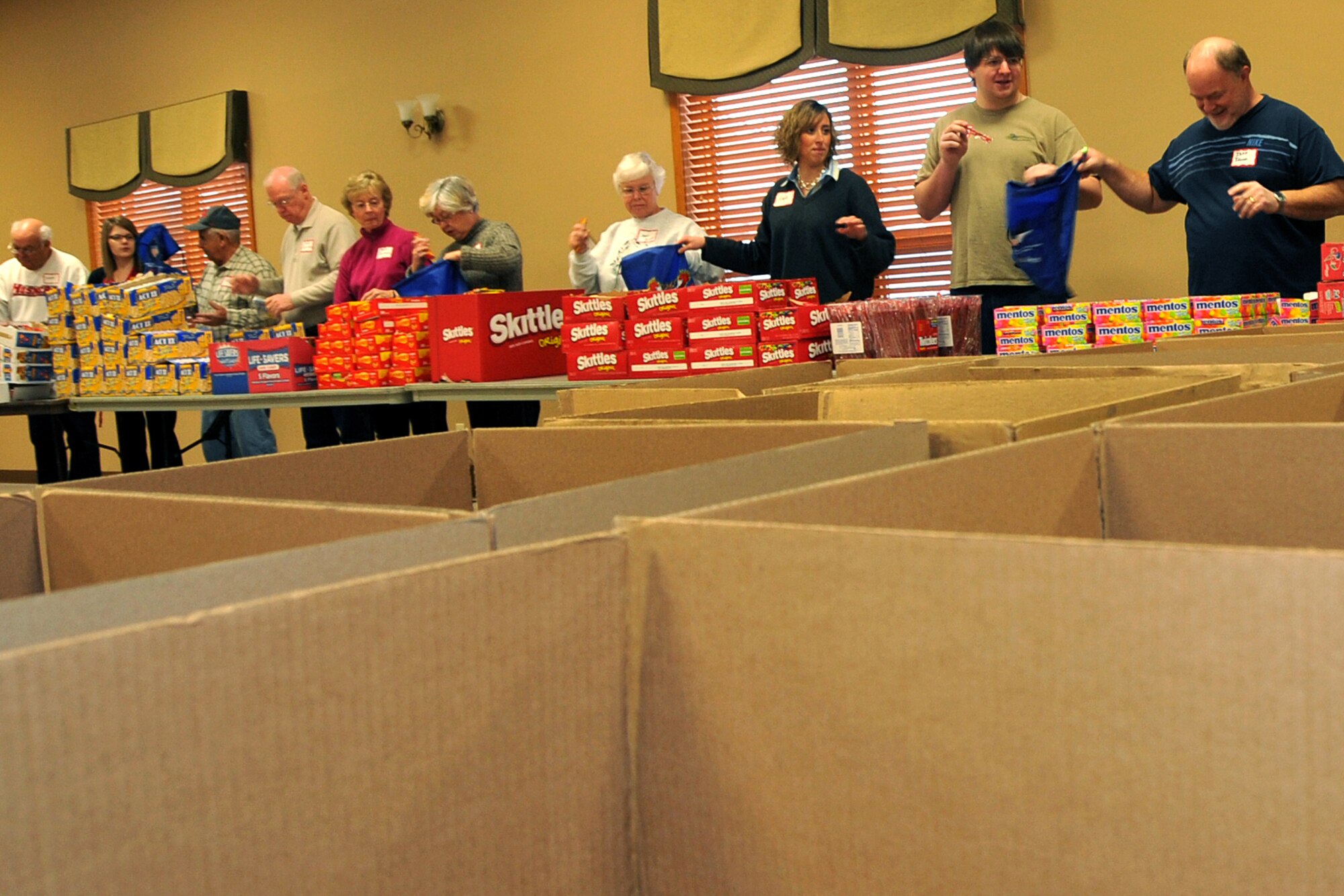 OFFUTT AIR FORCE BASE, Neb. - Volunteers join ranks to fill holiday cheer bags for the Bellevue Chamber of Commerce on Dec. 13. Military members and civilians were on hand to fill snack bags up for local dorm residents at Offutt. U.S. Air Force Photo by Jeff W. Gates (Released)