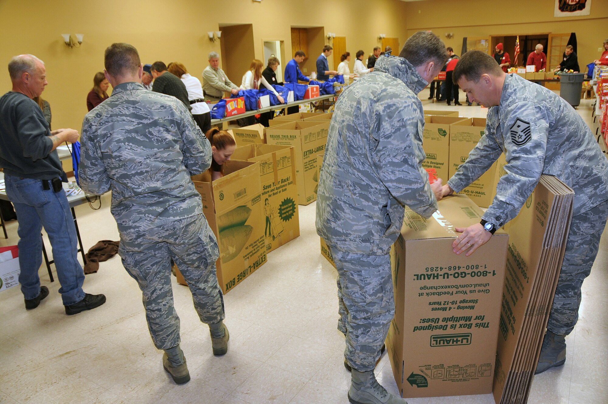 OFFUTT AIR FORCE BASE, Neb. - Volunteers join ranks to fill holiday cheer bags for the Bellevue Chamber of Commerce on Dec. 13. Military members and civilians were on hand to fill snack bags up for local dorm residents at Offutt. U.S. Air Force Photo by Jeff W. Gates (Released)