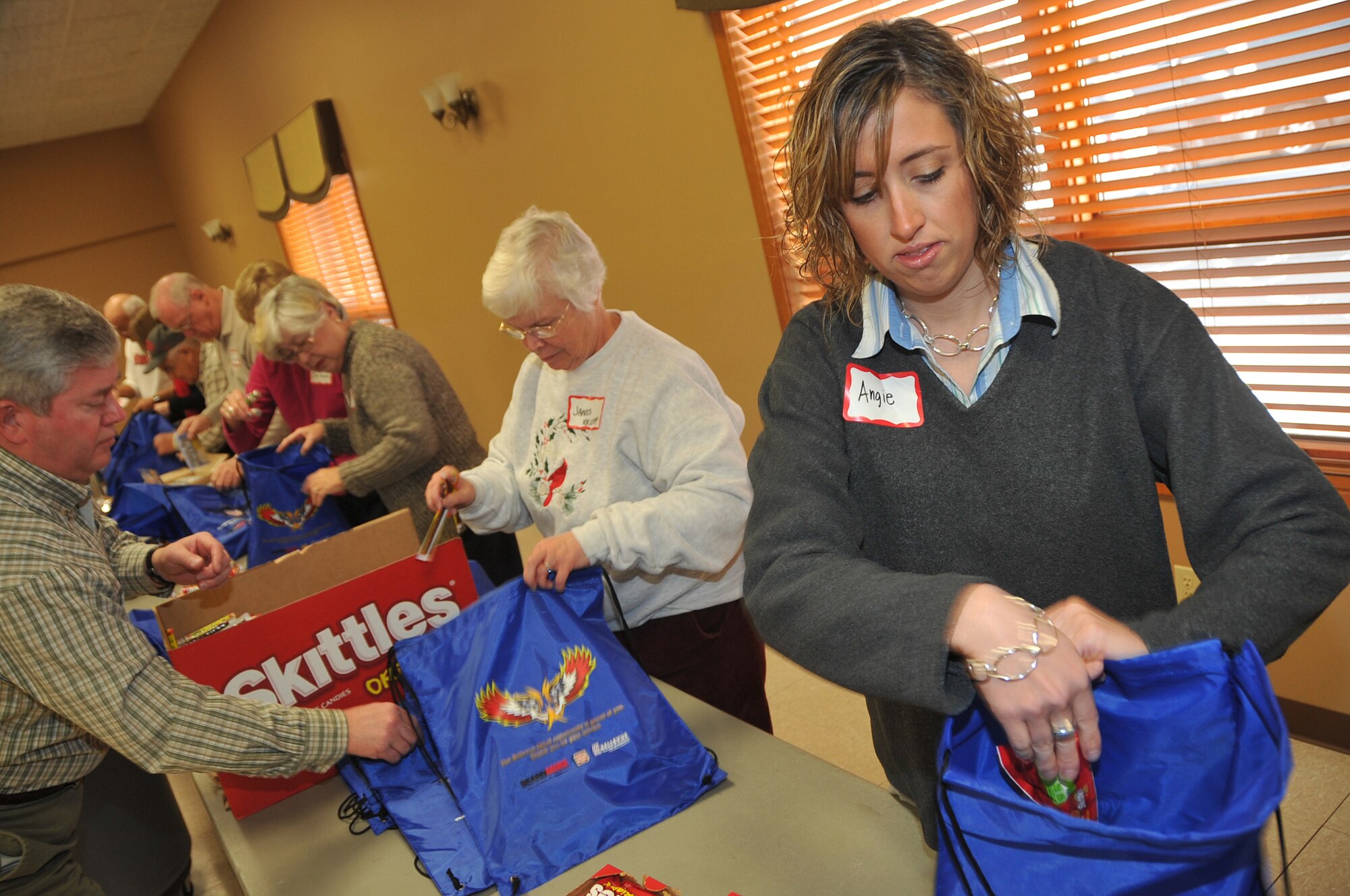 OFFUTT AIR FORCE BASE, Neb. - Angie Wade, a graphic designer for Bellevue Public Schools, helps fill holiday cheer bags for the Bellevue Chamber of Commerce on Dec. 13. Military members and civilians were on hand to fill snack bags up for local dorm residents at Offutt. U.S. Air Force Photo by Jeff W. Gates (Released)