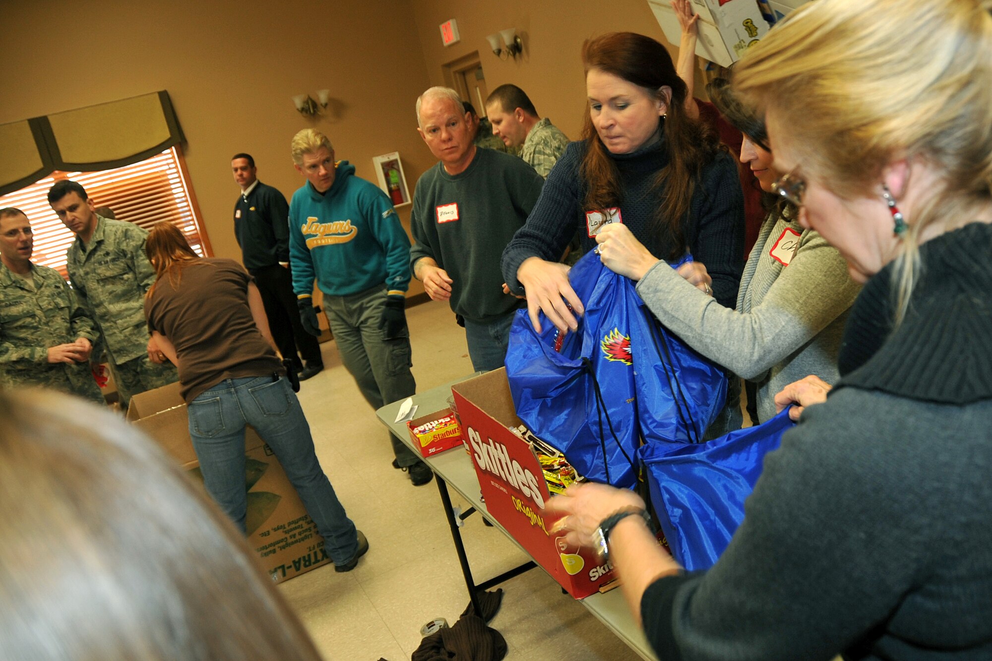 OFFUTT AIR FORCE BASE, Neb. - Laura Shanahan, wife of 55th Wing commander Brig. Gen. John N.T. Shanahan fill holiday cheer bags for the Bellevue Chamber of Commerce on Dec. 13. Military members and civilians were on hand to fill snack bags up for local dorm residents at Offutt. U.S. Air Force Photo by Jeff W. Gates (Released)
