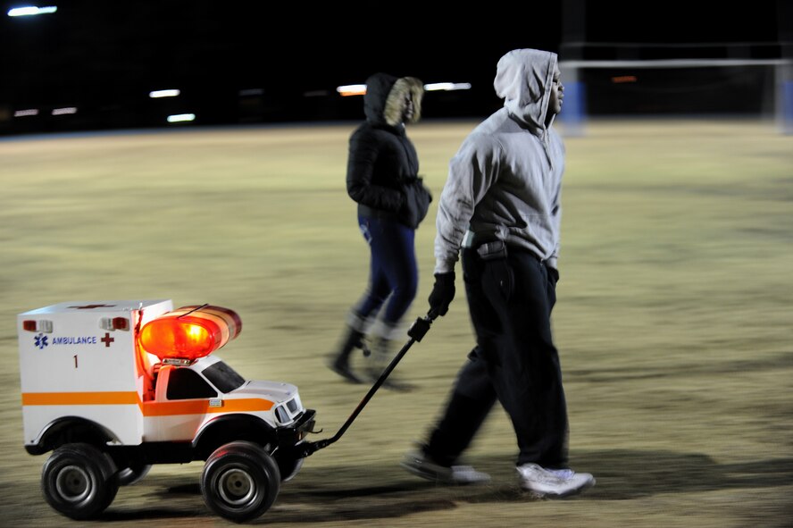 MOODY AIR FORCE BASE, Ga. -- Tremaine Jones pulls a miniature ambulance across a football field Dec. 13. The miniature ambulance was the mascot for the 23rd Medical Group’s flag football team. During the championship game, supporters sounded the ambulance’s alarm when the group’s team scored. (U.S. Air Force photo/Airman 1st Class Douglas Ellis)(RELEASED)