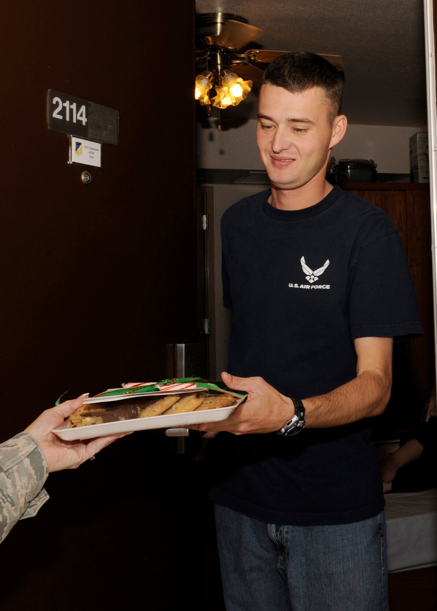HOLLOMAN AIR FORCE BASE, N.M. -- Airman 1st Class Christopher Rainwater, 49th Security Forces Squadron, receives a package containing two dozen cookies, a candy cane and a card handmade by an Elementary or Middle school student from a First Sergeant Dec. 13, 2010. The packages were made for the annual Airman Cookie Drive, where members of Team Holloman and the local community baked cookies for Airmen living in the dorms. The goal for this year was to give each Airman a dozen cookies, but with all the contributions from the local community, the Airmen received two dozen each. (U.S. Air Force photo by Airman 1st Class Eileen Payne/Released)
