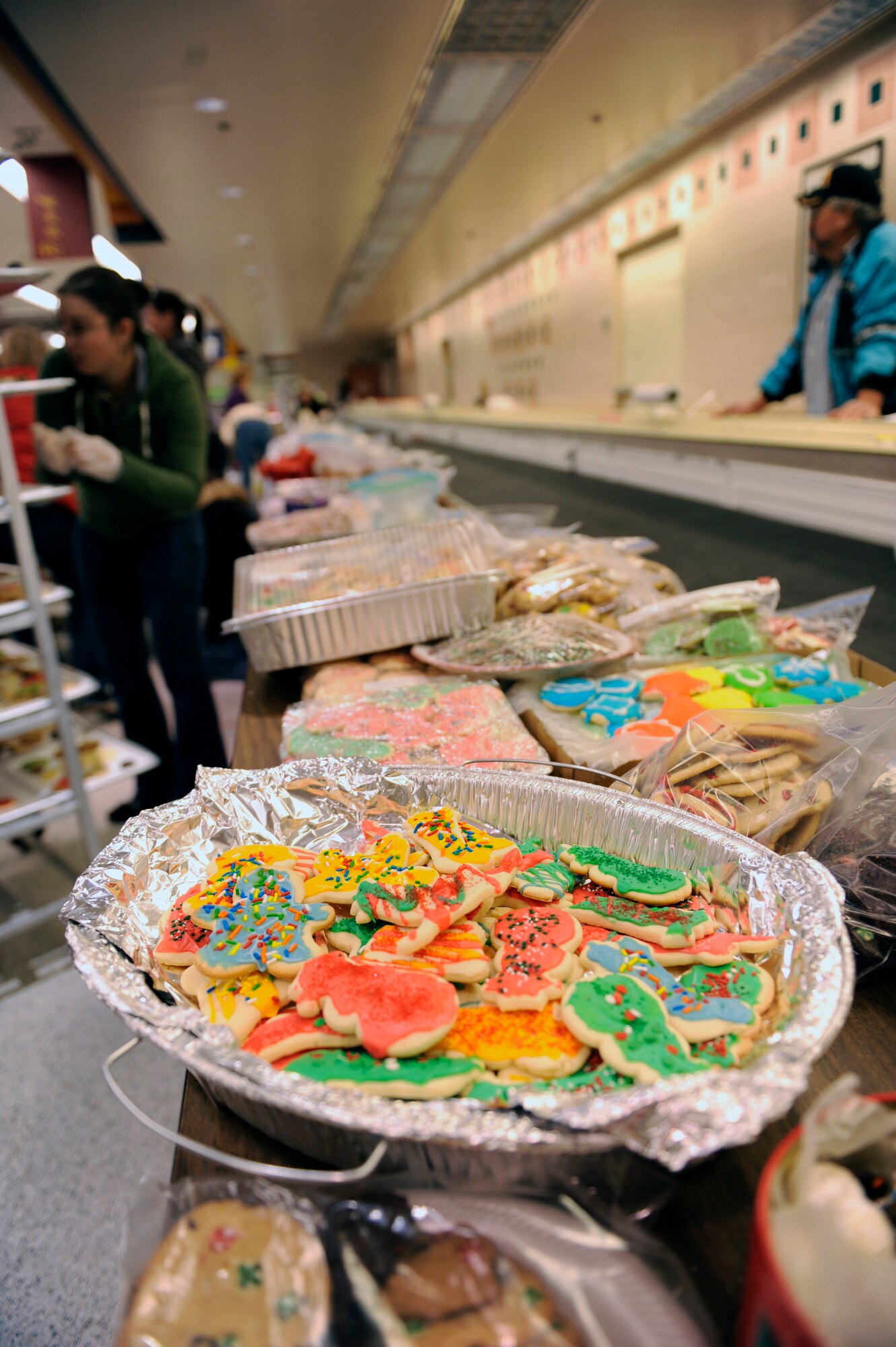 HOLLOMAN AIR FORCE BASE, N.M. -- Volunteers from the Alamogordo community and Team Holloman work together to sort out cookies on trays for the annual Airman Cookie Drive at the base commissary Dec. 13, 2010. The goal for this year was 600 dozen, but with so many contributions the mark was doubled. Once the cookies were wrapped, the First Sergeants personally delivered them to each Airman living in the dorms. (U.S. Air Force photo by Airman 1st Class Eileen Payne/Released)