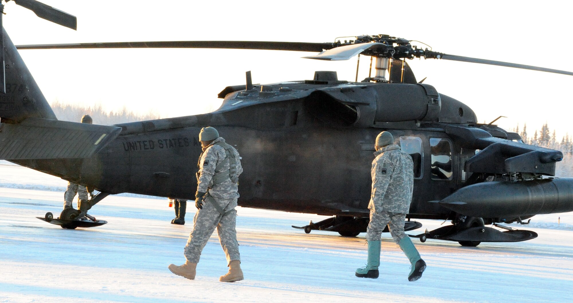 Army pilots assigned to Alpha Company 1-52 Aviation, 16th combat aviation brigade, walk to the UH-60 Black Hawks in preparation for flight in sub-arctic temperatures at Eielson Air Force Base, Alaska Dec. 8, 2010. The pilots landed at Eielson to refuel during a routine training mission. (U.S. Air Force photo/Airman 1st Class Laura Goodgame) 