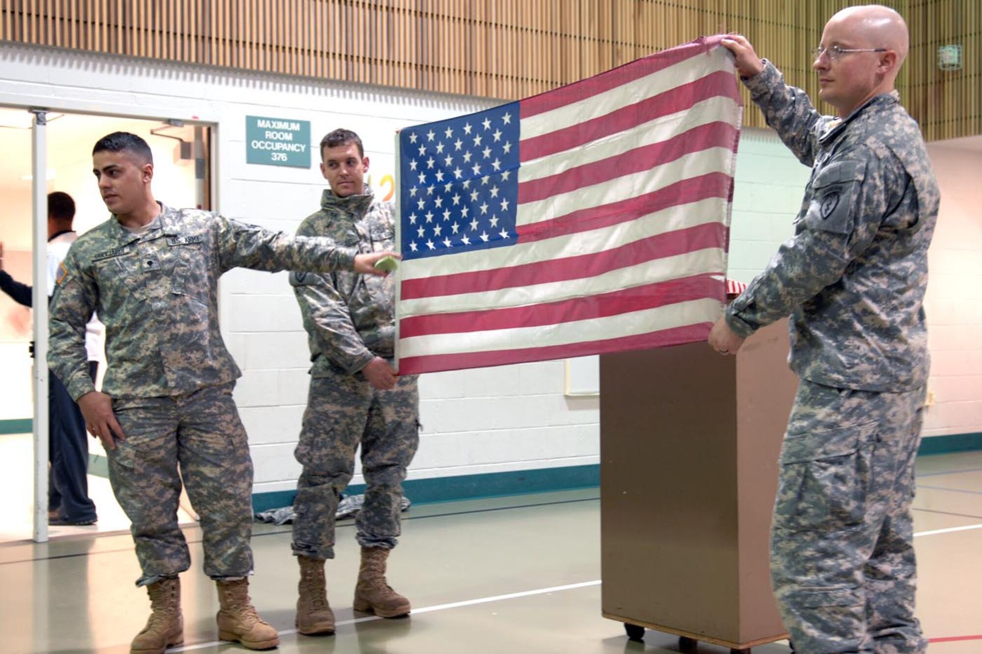 Spc. Joseph Gucciardi,2nd Battalion, 377th Parachute Field Artillery Regiment, explains the meaning of the red, white, and blue colors and shapes which adorn the American Flag. (Photo by Army Staff Sgt. Matthew E. Winstead/4th Brigade Combat Team (Airborne), 25th Infantry Division PAO)
