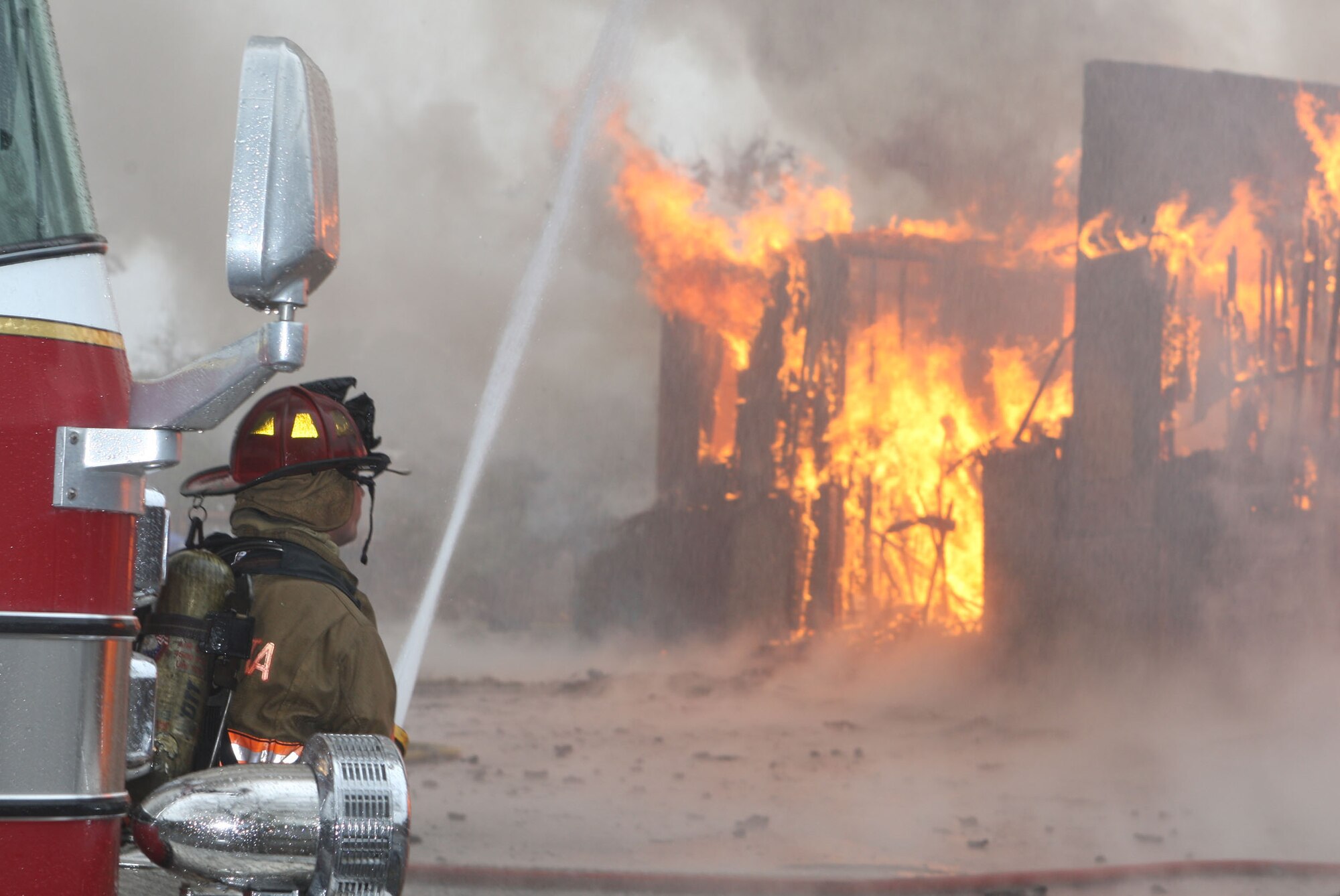 Fire Crews from both the Dobbins Fire and Emergency Services and Marietta Fire Department team up to perform a live fire training scenario. (U.S. Air Force Photo/Don Peek) 