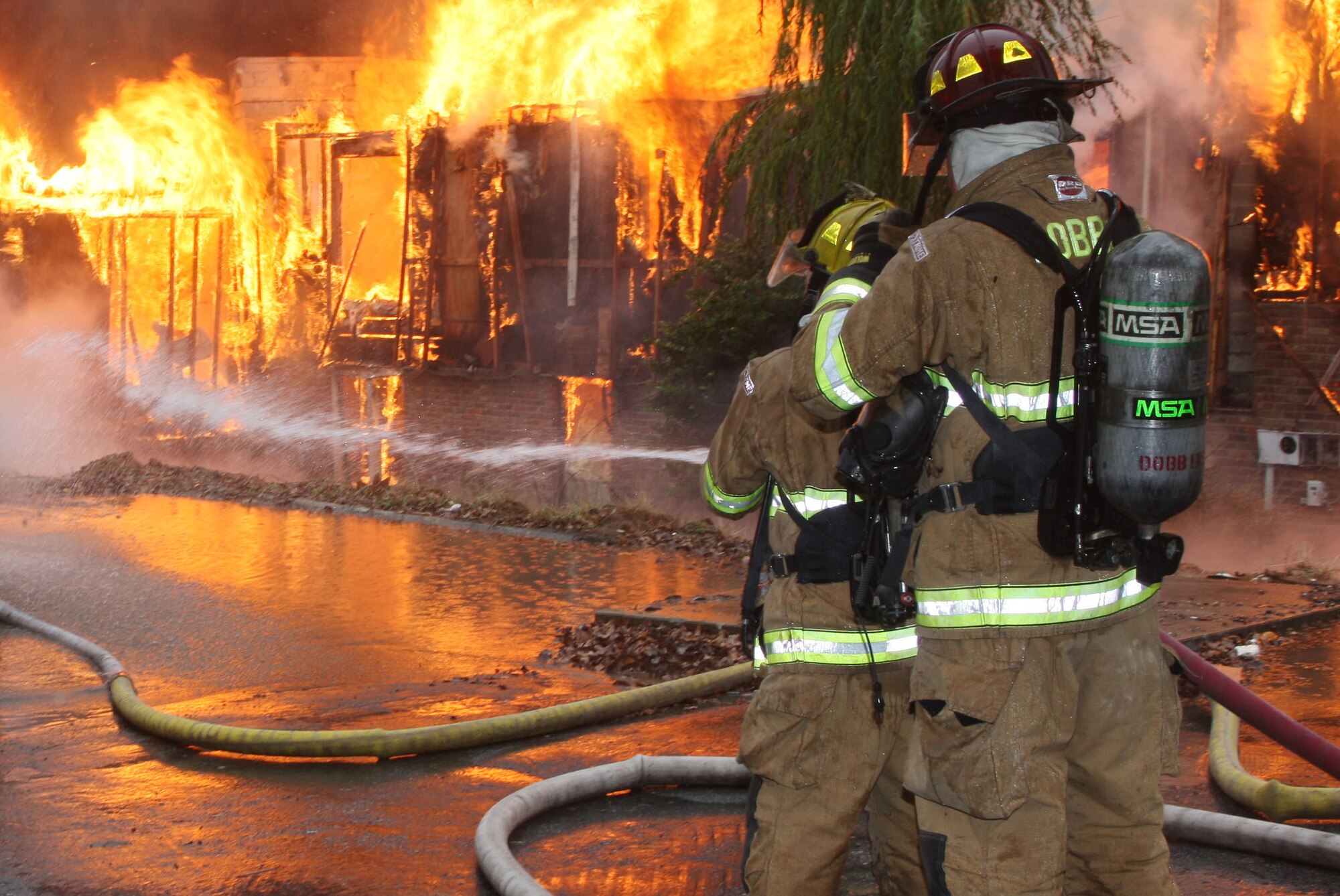 Firefighters from Dobbins Fire and Emergency Services take on the blaze as it completely consumes the apartment complex in live fire training. (U.S. Air Force Photo/Don Peek) 