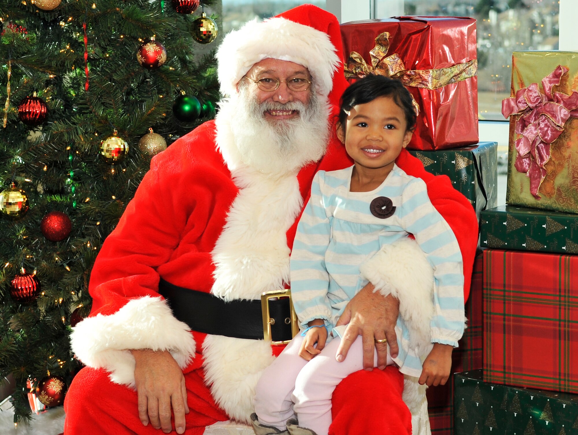 BUCKLEY AIR FORCE BASE, Colo. -- Mr. Claus poses with 4year old Ava Petty daughter of Lt.Col. George Petty,460th Civil Engineer Squadron Commander on Dec. 11, 2010. Santa posed for photos with children to allow keepsakes for the parents.(Airman 1st Class Paul Labbe.)