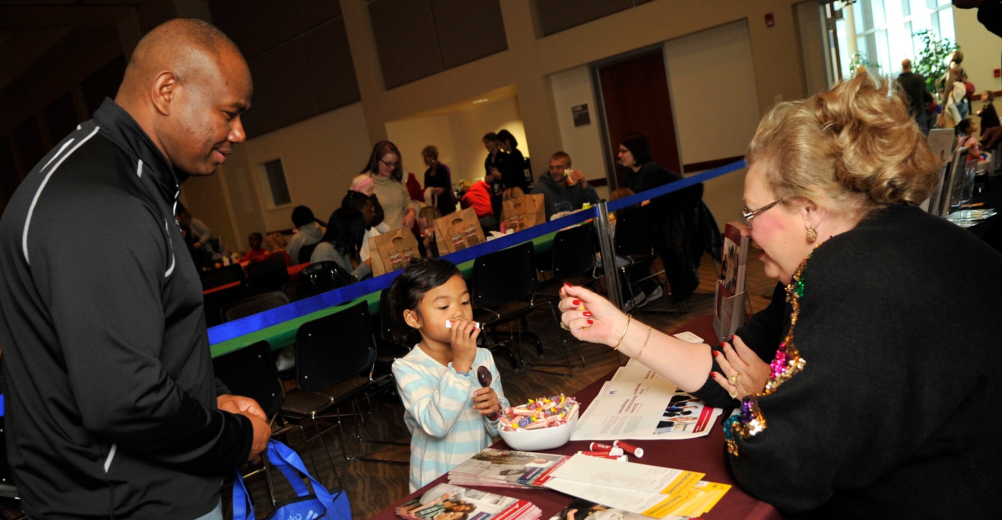 BUCKLEY AIR FORCE BASE, Colo. -- Lt.Col George Petty, 460th Civil Engineer Squadron Commander, and his daughter Ava Petty speaks with a sponsor at the breakfast with Santa event. Sponsors such as USAA, and the Colorado Technical University came to help share information to guest.(Airman 1st Class Paul Labbe.)