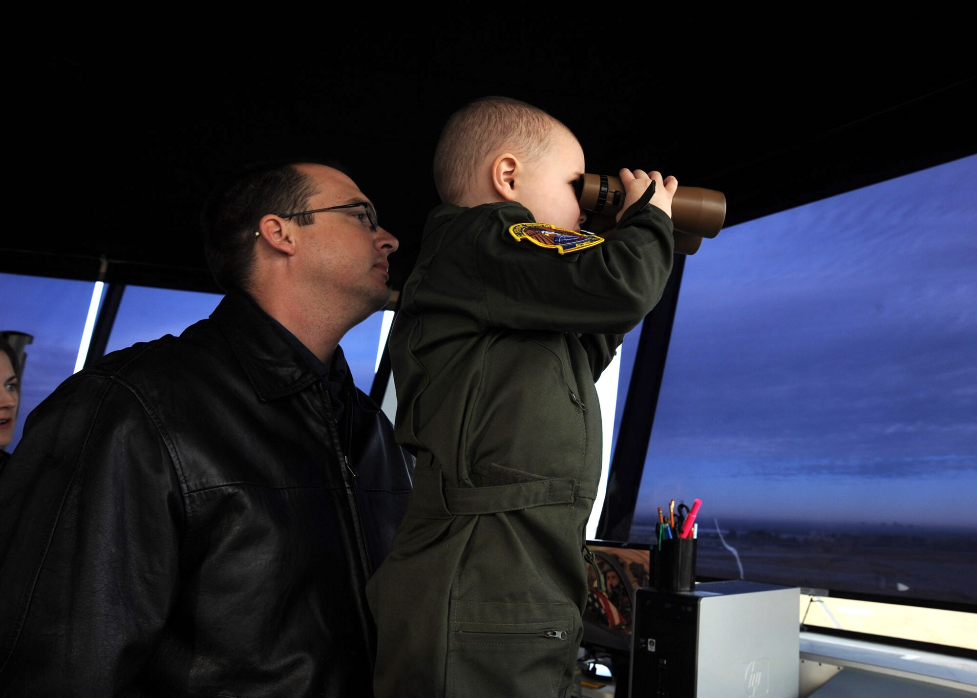Five-year-old Joey Bacon, Pilot For a Day recipient, looks through a pair of binoculars with Jon Bacon, his father, during a tour of the air traffic control tower Dec. 10, 2010, McConnell Air Force Base, Kan. Joey, who has been diagnosed with leukemia, toured the base with members of the 22nd Operations Support Squadron as part of the Pilot for a Day program. Joey and his family were given a VIP tour of McConnell where they visited the base fire department, “flew” a KC-135 Stratotanker simulator, toured the air traffic control tower and met the military working dogs. (U.S. Air Force photo/Staff Sgt. Dallas Edwards)