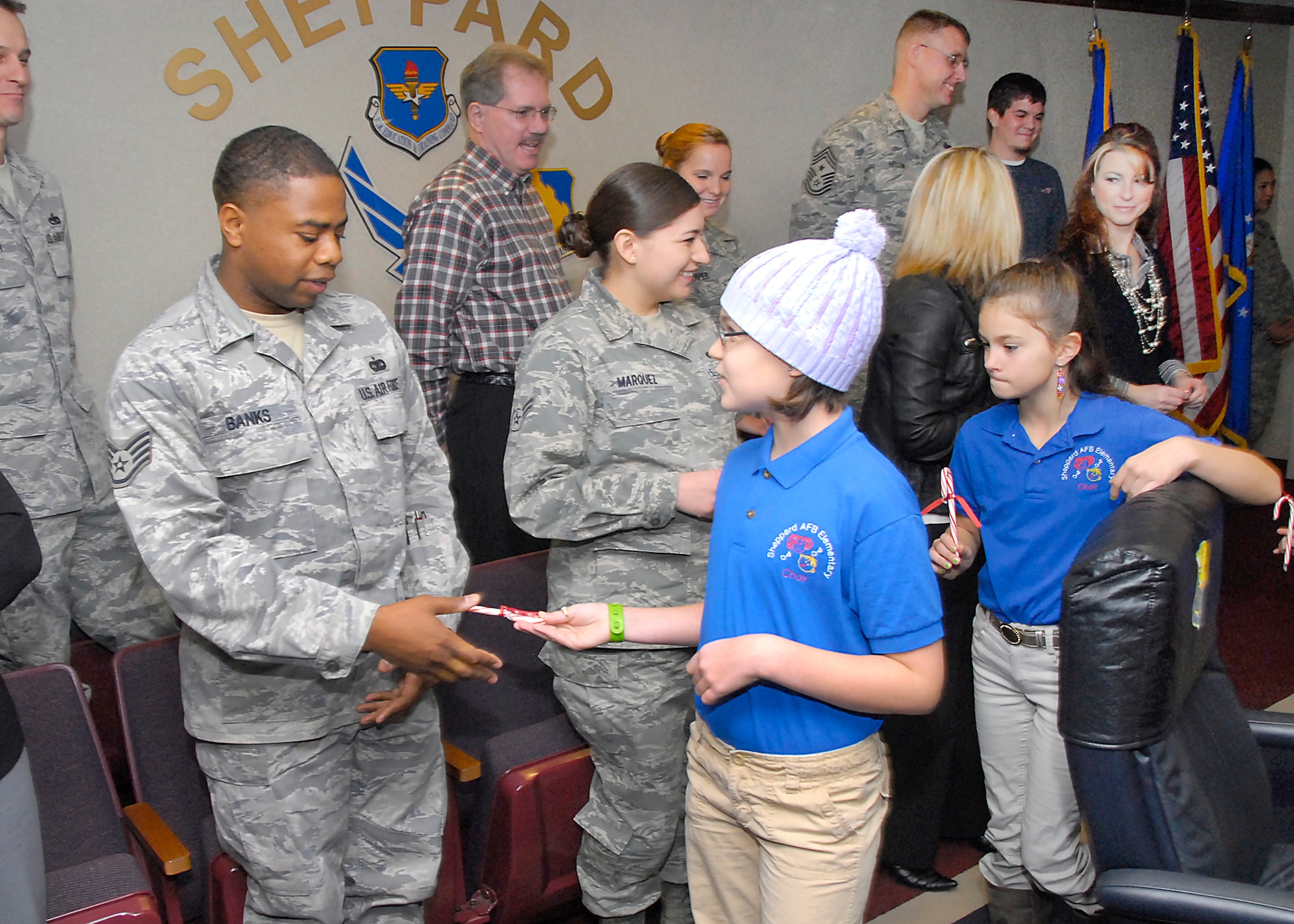 Sheppard Elementary School students pass out candy canes to occupants of the 82nd Training Wing headquarters building Dec. 13. The students perform for wing leadership and others during this time of the year to help usher in the holiday season. (U.S. Air Force photo/Harry Tonemah)