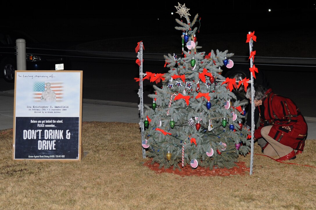 BUCKLEY AIR FORCE BASE, Colo.-- The parents of Senior Airman Kristopher Mansfield light a tree at the 460th Space Communications Squadron on Dec. 14, 2010. Airman Mansfield was killed by a drunk driver in 2004. (U.S. Air Force photo by Airman Manisha Vasquez) 