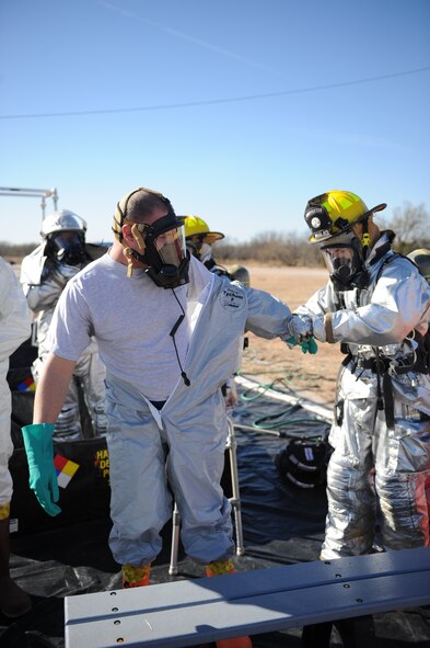 DYESS AIR FORCE BASE, Texas—A Dyess firefighter goes through the decontamination process with Staff Sgt. Jesse Kirkland, 7th Civil Engineer Squadron, Dec. 10 during an emergency management exercise at the cantonment area here. EMEs are conducted to test the wings capability to respond and coordinate with agencies off base in real world emergencies.  (U.S Air Force photo/ Airman 1st Class Shannon Hall)