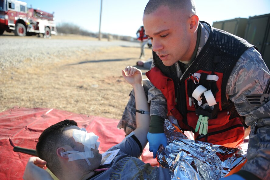 DYESS AIR FORCE BASE, Texas—Senior Airman Jordan Clark, 7th Medical Operations Squadron,  treats Senior Airman Rick Brooks, 7th Equipment Maintenance Squadron, for an eye injury and shock Dec. 10 during an emergency management exercise at the cantonment area here.  EMEs are conducted to test the wings capability to respond and coordinate with agencies off base in real world emergencies.  (U.S Air Force photo/ Airman 1st Class Shannon Hall)