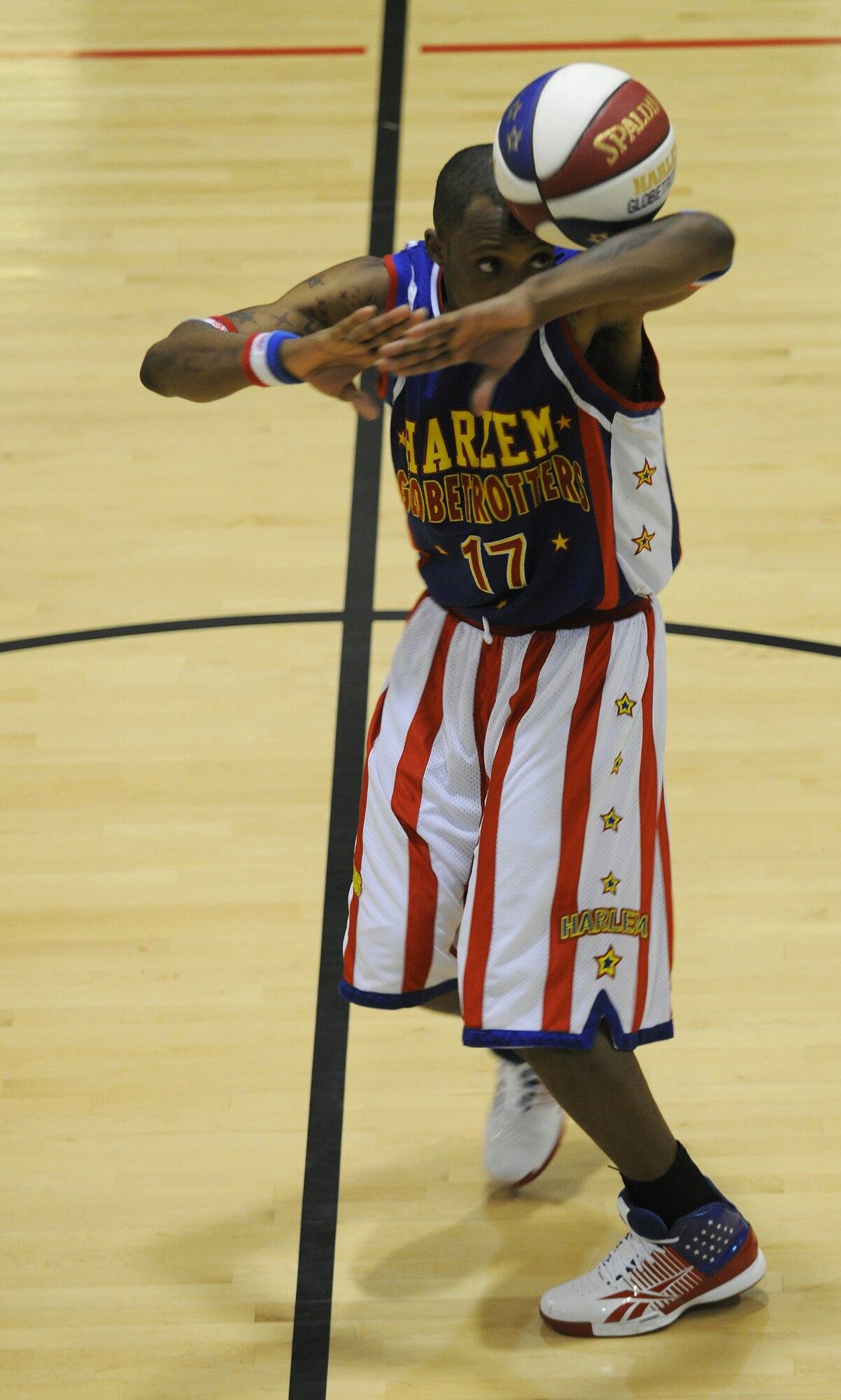 RAF MILDENHALL, England -- Rocket Rivers dances around with a basketball rolling around his arms here Dec. 11, 2010.  The Harlem Globetrotters' performance combines athleticism, theater and comedy for family friendly entertainment. (U.S. Air Force photo/Senior Airman Tabitha M. Lee)