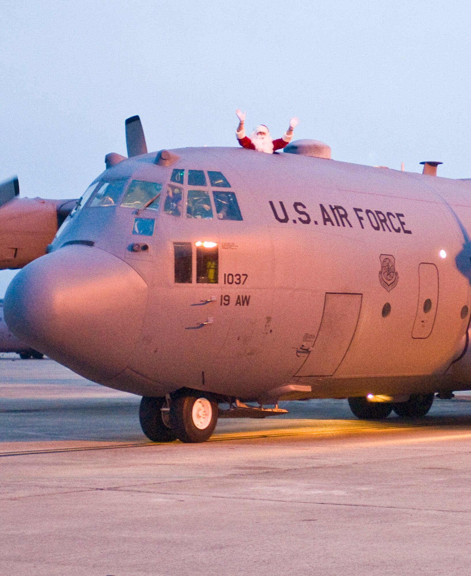 Santa Claus waves to children from a C-130 as it taxis to a parking spot Dec. 10, 2010, at Little Rock Air Force Base, Ark. Santa brought holiday cheer and presents to children of deployed Airmen during the 53rd AS family holiday party. (U.S. Air Force photo by Staff Sgt. Nestor Cruz)