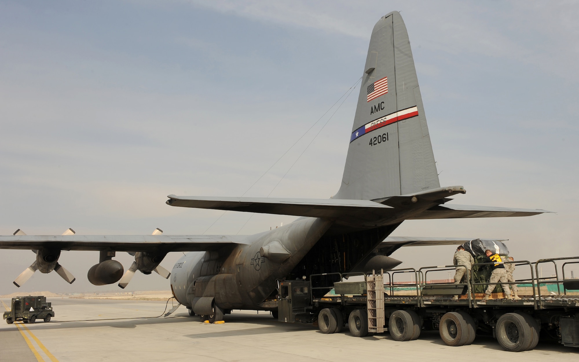 SOUTHWEST ASIA -- Airmen and Soldiers help load Container Delivery System bundles into the back of a C-130 Hercules at Bagram Air Field, Afghanistan, recently. For the first time since the 386th Air Expeditionary Wing stood up more than a decade ago, a crew from the wing's 737th Expeditionary Airlift Squadron flew over the mountains of Afghanistan and dropped more than 22,000 pounds of supplies to ground troops Nov. 21, validating the wing's ability to perform airdrop missions in support of Operation Enduring Freedom. 