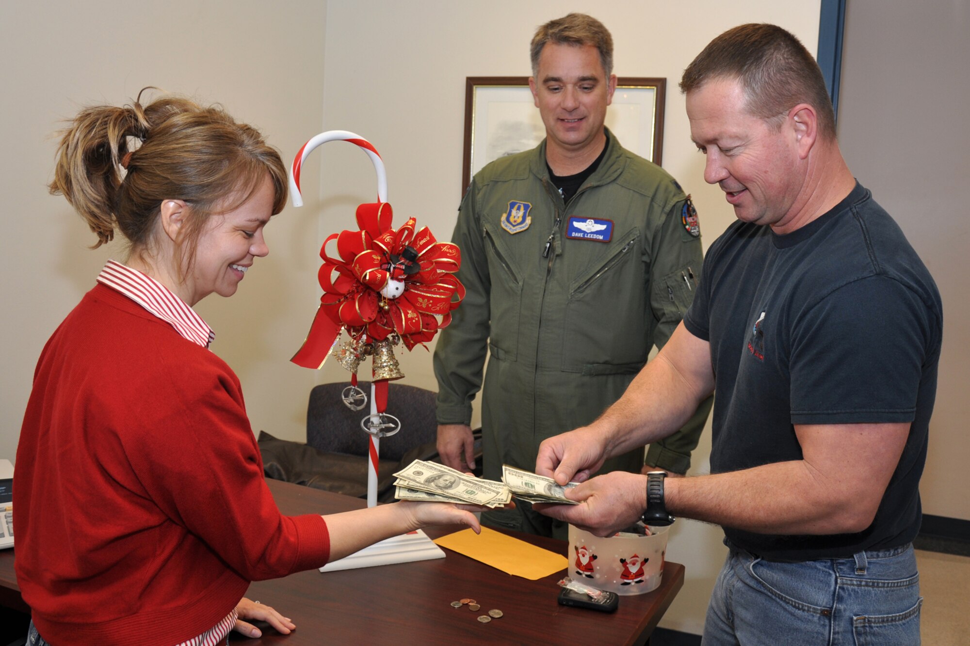 Lt. Col. Dave Leedom, director of operations, 93rd Bomb Squadron, looks on as Senior Master Sgt. Darren Ellingwood, 917th Operations Group, presents Master Sgt. Rachell Wood, 917th Wing, with $1,608.93 in donations from the 93rd Bomb Squadron for the “Santa’s In Blue” campaign, at Barksdale Air Force Base, La., Dec. 10, 2010. The 93rd BS captured the “Spirit Award” again this year for donating the largest amount of money from among 18 different units competing within the 917th Wing. The monies will be used to buy toys for foster children in the area. Both Sergeants Ellingwood and Wood are Air Reserve Technicians at the 917th Wing. (U.S. Air Force photo illustration/Tech. Sgt. Jeff Walston)
