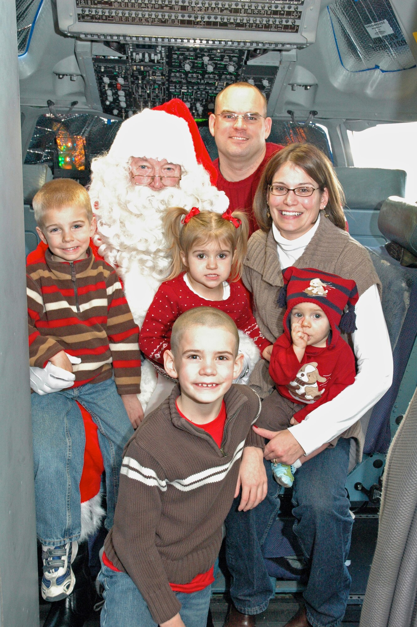 The Fick family has their photo taken with Santa Claus on board a C-17 aircraft on the Dover Air Force Base, Del., flightline Dec. 5, 2010. The event was sponsored by the Dover AFB Airman & Family Readiness Center for its second year. (U.S. Air Force photo by Senior Airman Danella Shea/Released)