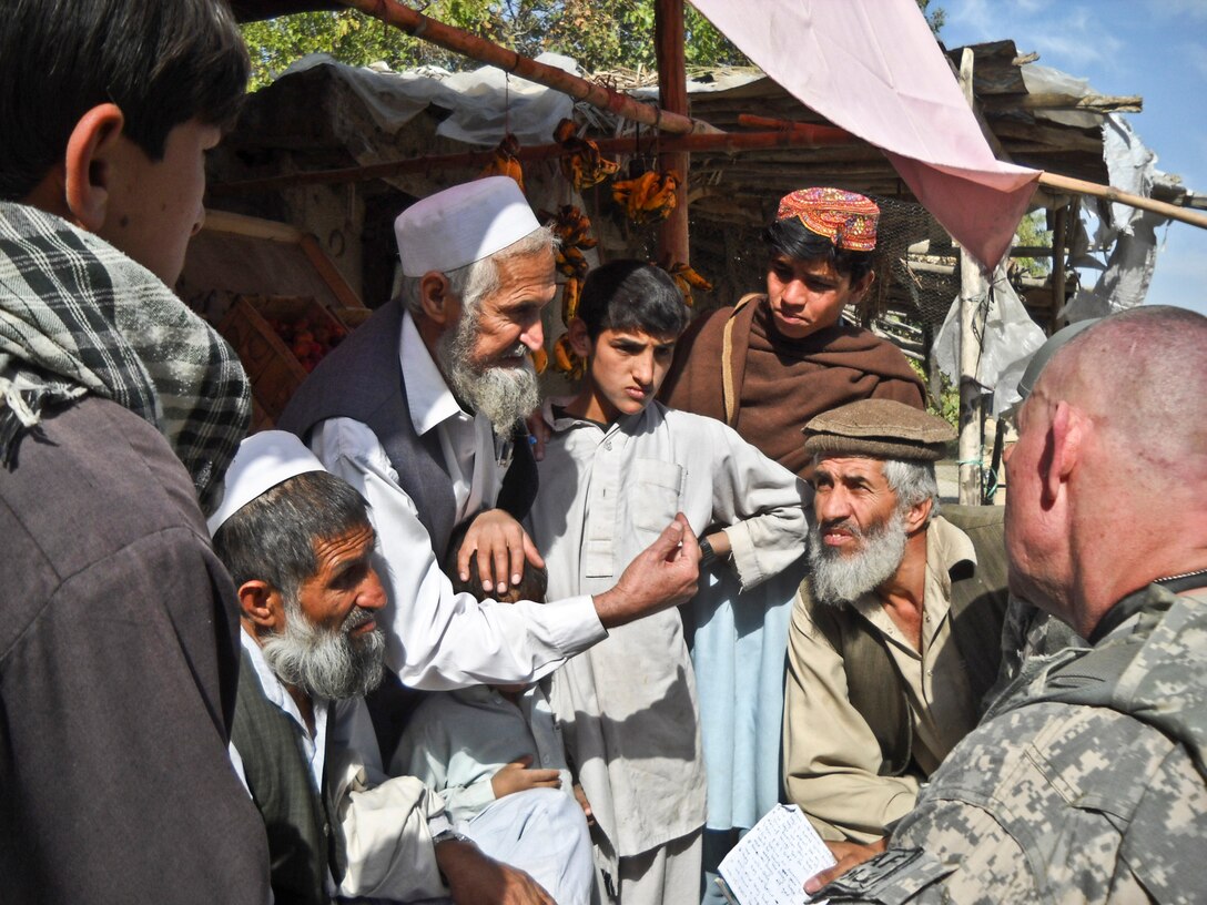 U.S. Army Staff Sgt. Robert Pharris, right, talks with farmers in the town of Memlah, Nangarhar Province, Afghanistan, Nov. 9, 2010. Pharris and the other 12 members of the ADT have been working with the Afghan government to introduce new methods of farming to the farmers of the Khogyani district. 