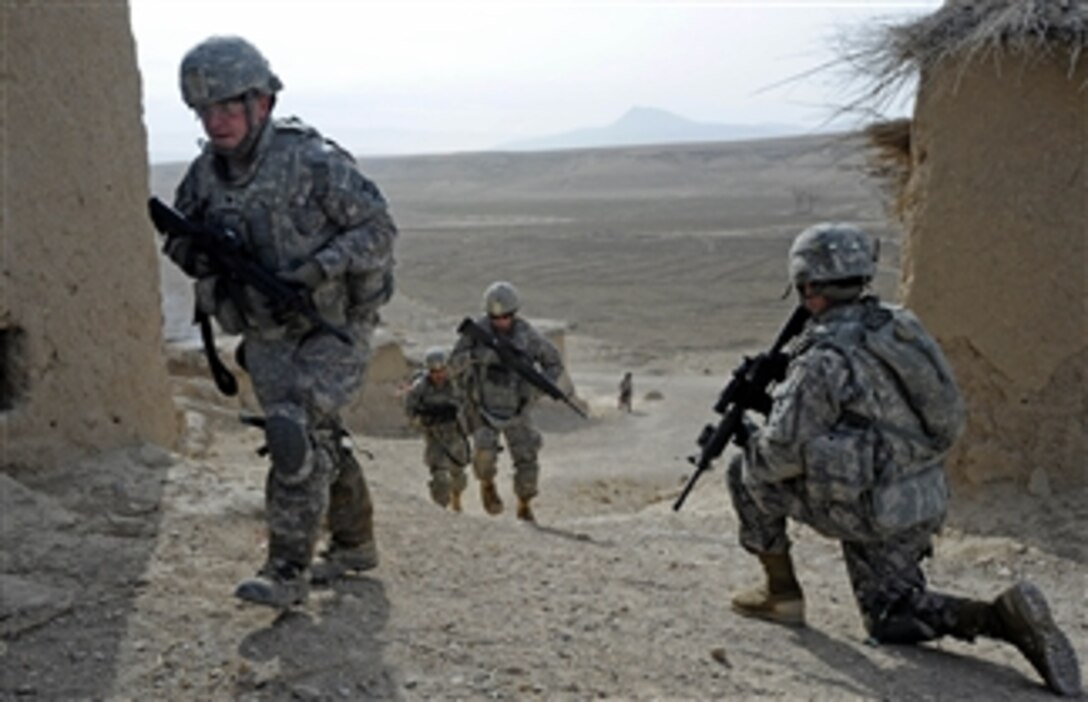 U.S. Army Spc. Erik Martin (left), with the Zabul Provincial Reconstruction Team, enters the village of Khwazi, Afghanistan, while on a dismounted mission to survey the village for a new well on Dec. 14, 2010.  The Zabul Provincial Reconstruction Team is comprised of Air Force, Army, U.S. Department of State, U.S. Agency for International Development and U.S. Department of Agriculture personnel who work with the government of Afghanistan to improve governance, stability and development throughout the province.  
