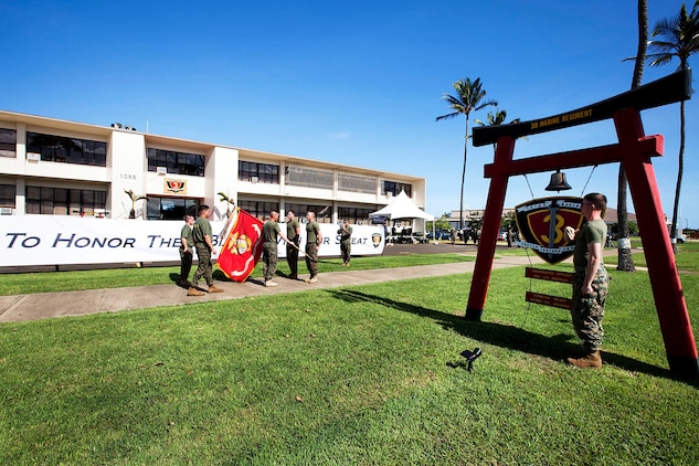 Lt. Col. Jeffrey Holt, commanding officer, 3rd Battalion, 3rd Marine Regiment, hands the 3rd Marine Regiment battle colors to Lance Cpl. Michael Murray, an assaultman with 2nd Battalion, 3rd Marine Regiment, during a Fallen Heroes Run, Dec. 15, 2010. Since 2004, 116 Marines and sailors from 3rd Marine Regiment have been killed during operations in Afghanistan and Iraq. On Dec. 14 and 15, teams of at least two Marines or sailors in combat boots and camouflage trousers ran a 2-mile evolution 116 times — one for each fallen hero. The route took them from the 3rd Marine Regiment headquarters building to the Pacific War Memorial here and back.