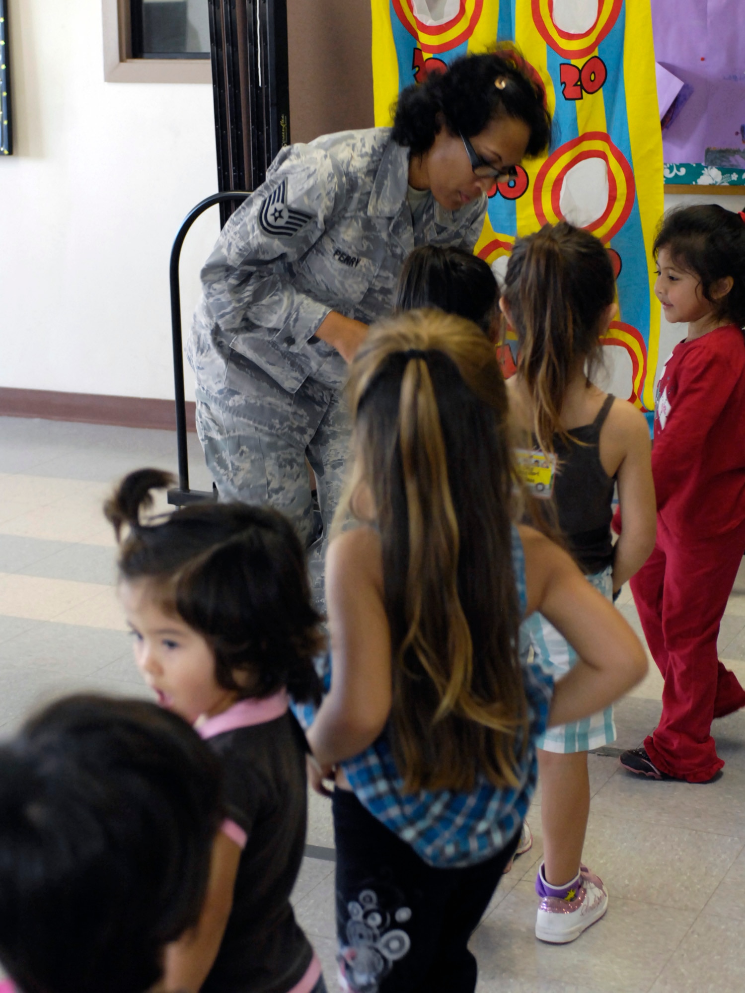 Tech. Sgt. Celeste Perry assists children with a game at the Oahu Head Start Program Holiday Party at the Makai Recreation Center at Joint Base Pearl Harbor-Hickam, Hawaii Dec. 16. A visit from Santa Claus, a magic show, and other activities highlighted the volunteer effort by base members to brighten the holiday spirit formore than 100 underpriviledged children. (U.S. Navy photo by David D. Underwood, Jr.)