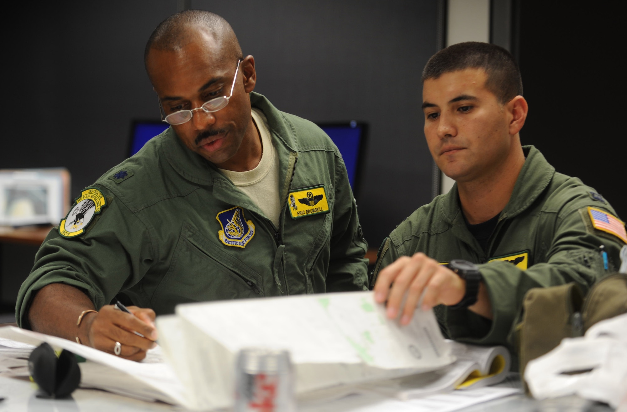 Lt. Col. Eric Brumskilll and Capt. James Rorick, KC-135 pilot's with the 96th Air Refueling Squadron, review flight plans for the second sortie of the squadron's first operational refueling mission, Dec. 15 at Joint Base Pearl Harbor-Hickam, Hawaii. During the mission, a 96th ARS KC-135 Stratotanker joined a KC-135 from the Iowa Air National Guard as part of a two-ship formation to refuel two B-52 Stratofortresses on the way to Guam. (U.S. Air Force photo/Airman 1st Class Lauren Main)