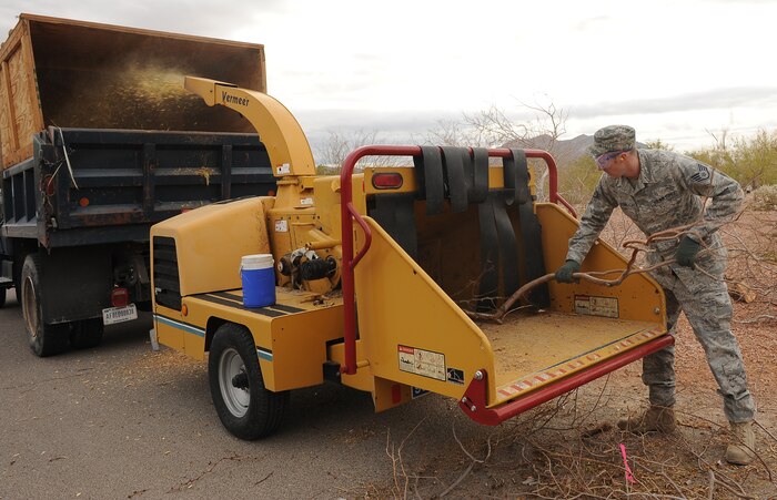 NELLIS AIR FORCE BASE, Nev.--  Staff Sgt. Erik Elder, 99th Communications Squadron systems technician, disposes of dead branches during a grove clean up Dec. 16. Every year, the 99th Civil Engineer Squadron's environmental flight is placed in charge of clearing the grove of dead or rotting plants, allowing the grove to stay healthy.   (U.S Air Force Photo by Senior Airman Stephanie Rubi)