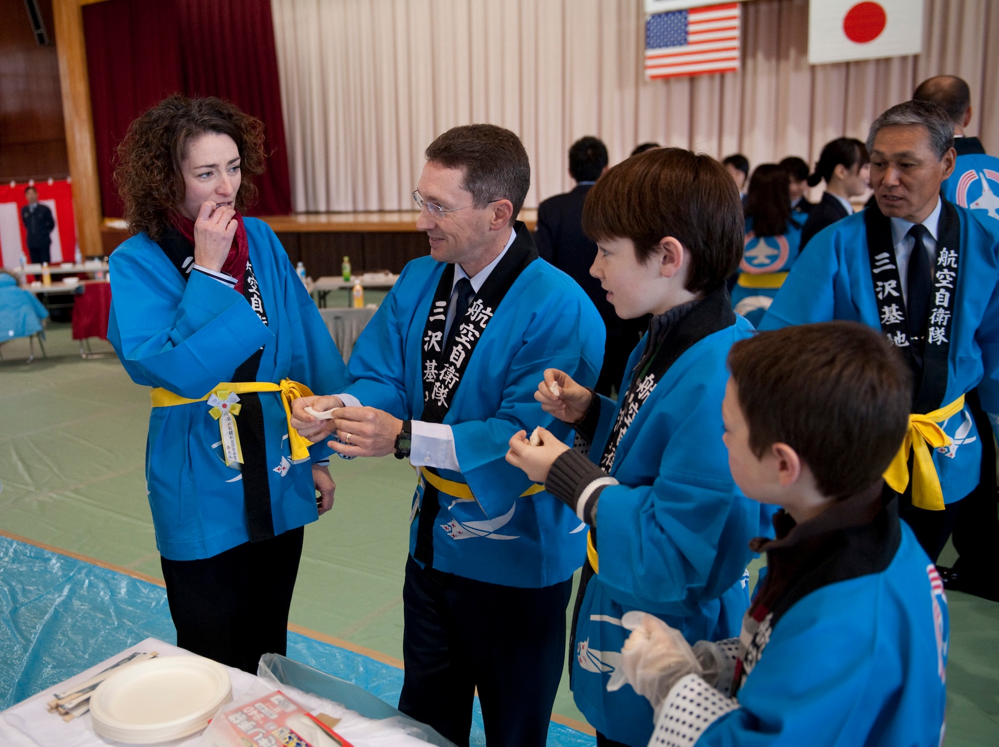 The Rothstein family tries freshly made mochi during the annual mochi pounding ceremony at the Japan Air Self-Defense Force gym, Misawa Air Base, Japan; Dec. 16, 2010. After taking turns pounding steamed rice into the traditional Japanese rice cakes, local dignitaries and their families were able to try the mochi. (U.S. Air Force photo by Staff Sgt. Samuel Morse/Released)
