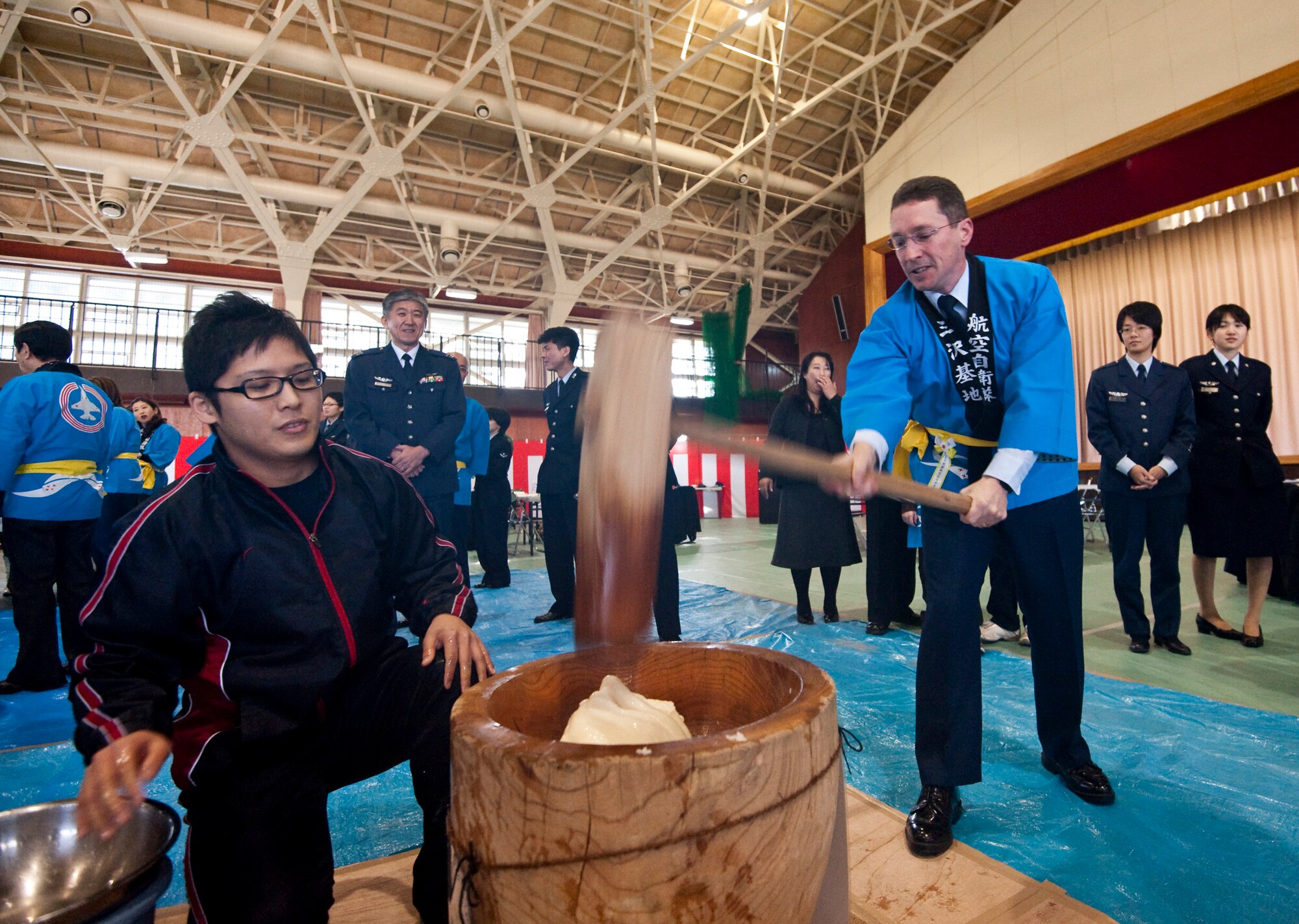 U.S. Air Force Col. Michael Rothstein, 35th Fighter Wing commander, pounds mochi during the annual mochi pounding ceremony at the Japan Air Self-Defense Force gym, Misawa Air Base, Japan; Dec. 16, 2010. Mochi is a type of rice cake made by pounding steamed, glutinous rice in a large wooden mortar with a large wooden mallet. (U.S. Air Force photo by Staff Sgt. Samuel Morse/Released)