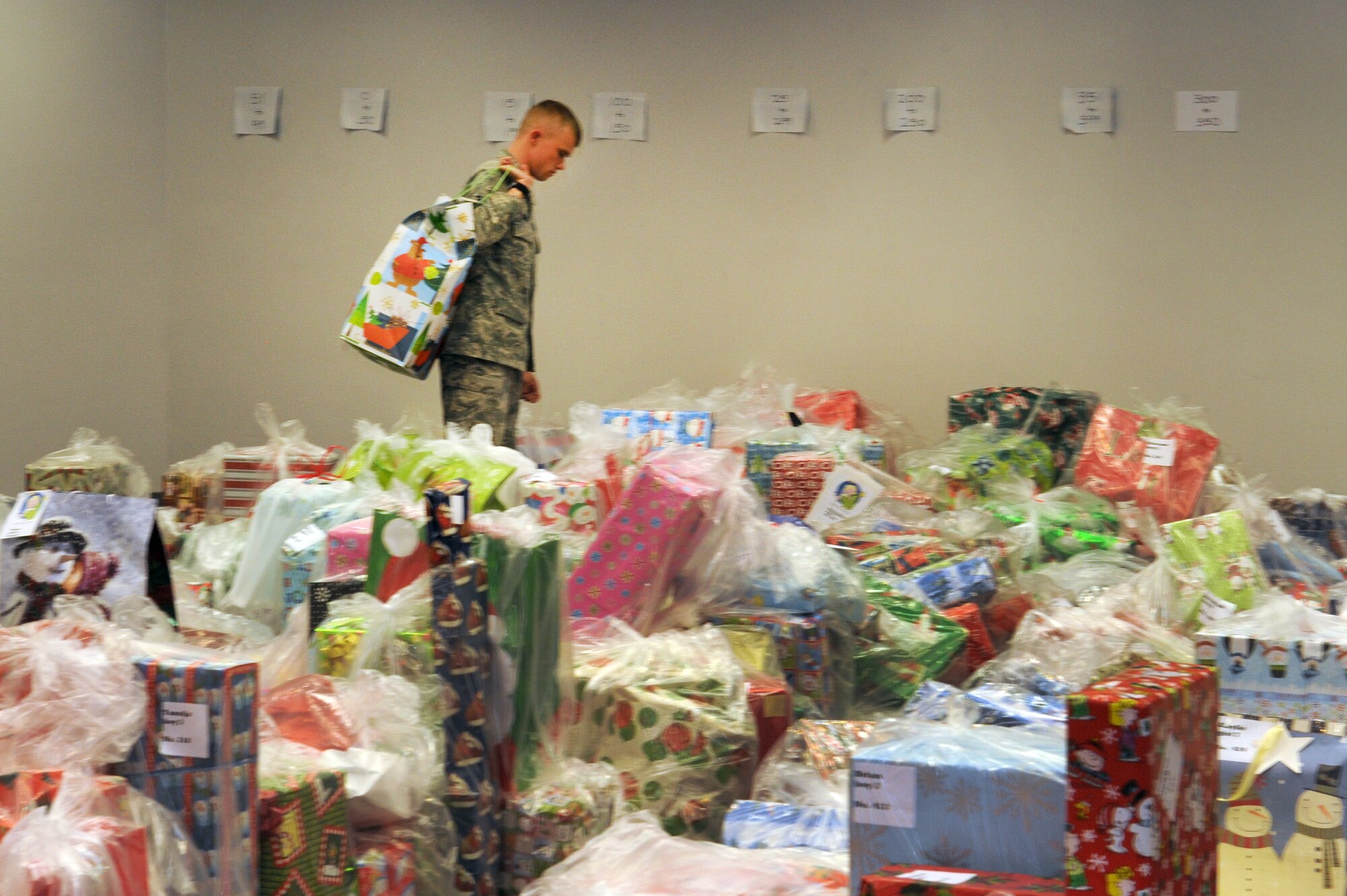 LAS VEGAS-- Senior Airman Nicholas Canole, an Angel Tree program volunteer from the 820th RED HORSE Squadron, looks for the right row to put gifts for Clark County foster children at Cashman Field Dec. 15. The 820th donated $5,000 worth of gifts to the Clark County Court Appointed Special Advocates sponsored annual Angel Tree party. (U.S. Air Force photo by Airman 1st Class Matthew Lancaster)