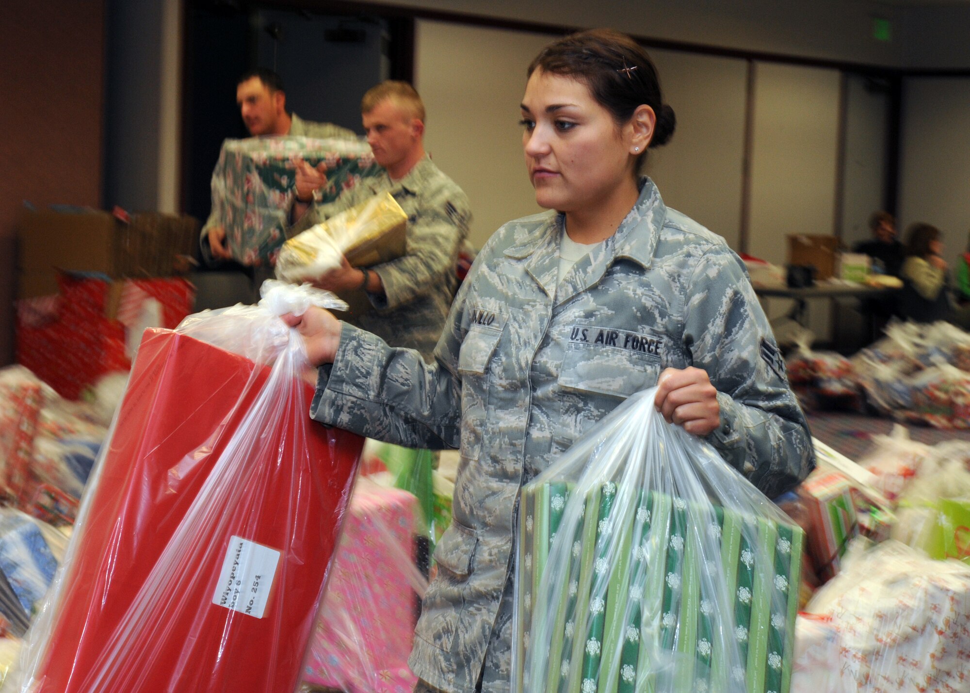 LAS VEGAS-- Airman 1st Class Victoria Trujillo, an Angel Tree program volunteer from the 820th RED HORSE Squadron, arranges gifts for Clark County foster children at Cashman Field Dec. 15. The 820th donated $5,000 worth of gifts to the Clark County Court Appointed Special Advocates sponsored annual Angel Tree party. (U.S. Air Force photo by Airman 1st Class Matthew Lancaster)