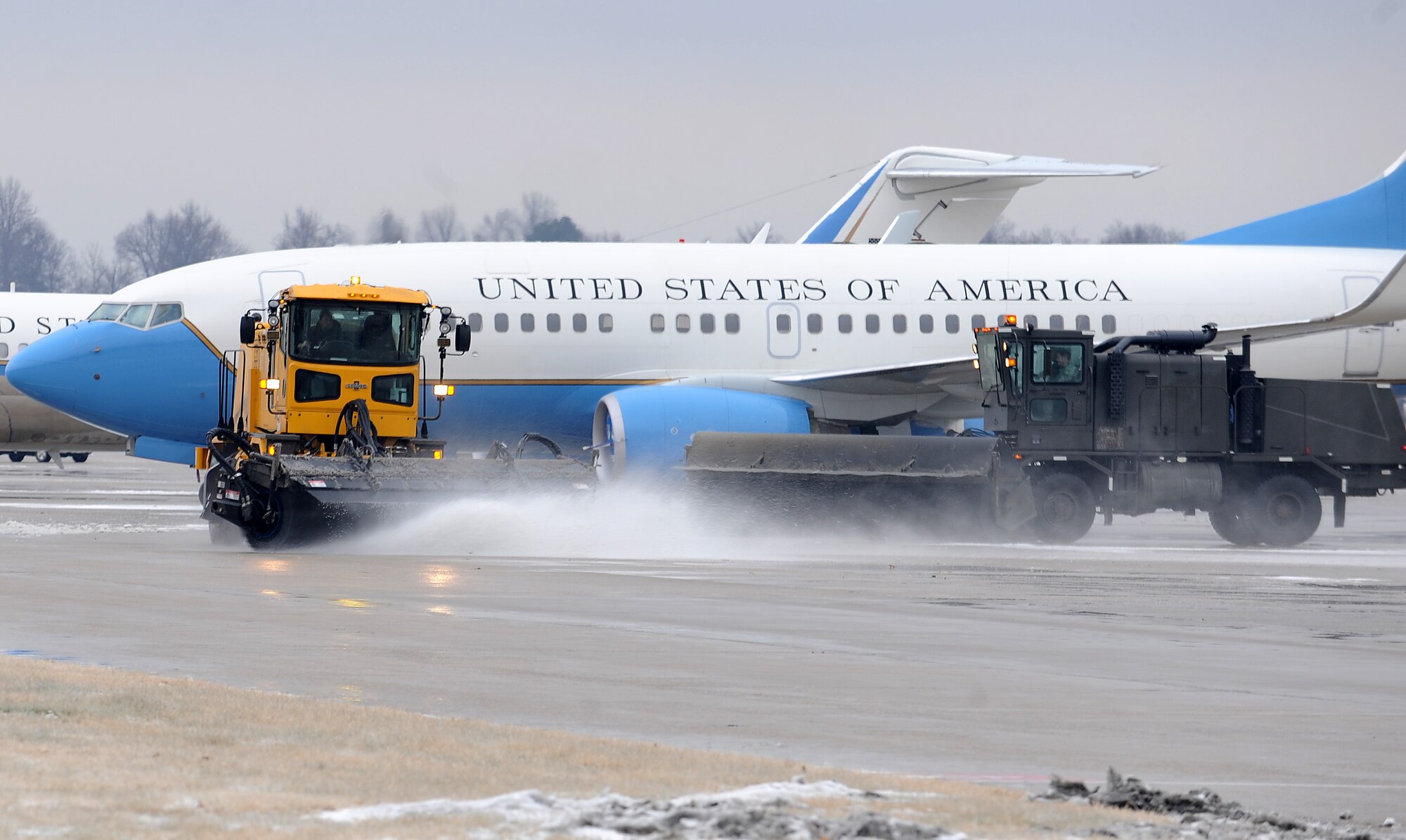 Members from 375th Civil Engineer Squadron Operations Flight, remove ice from the flightline with snow brooms Dec. 16, 2010, at Scott Air Force Base, Ill.  The 375th CES is responsible for making sure all roads on Scott are safe for all personnel to travel on. (U.S. Air Force photo/ Airman 1st Class Divine Cox) 