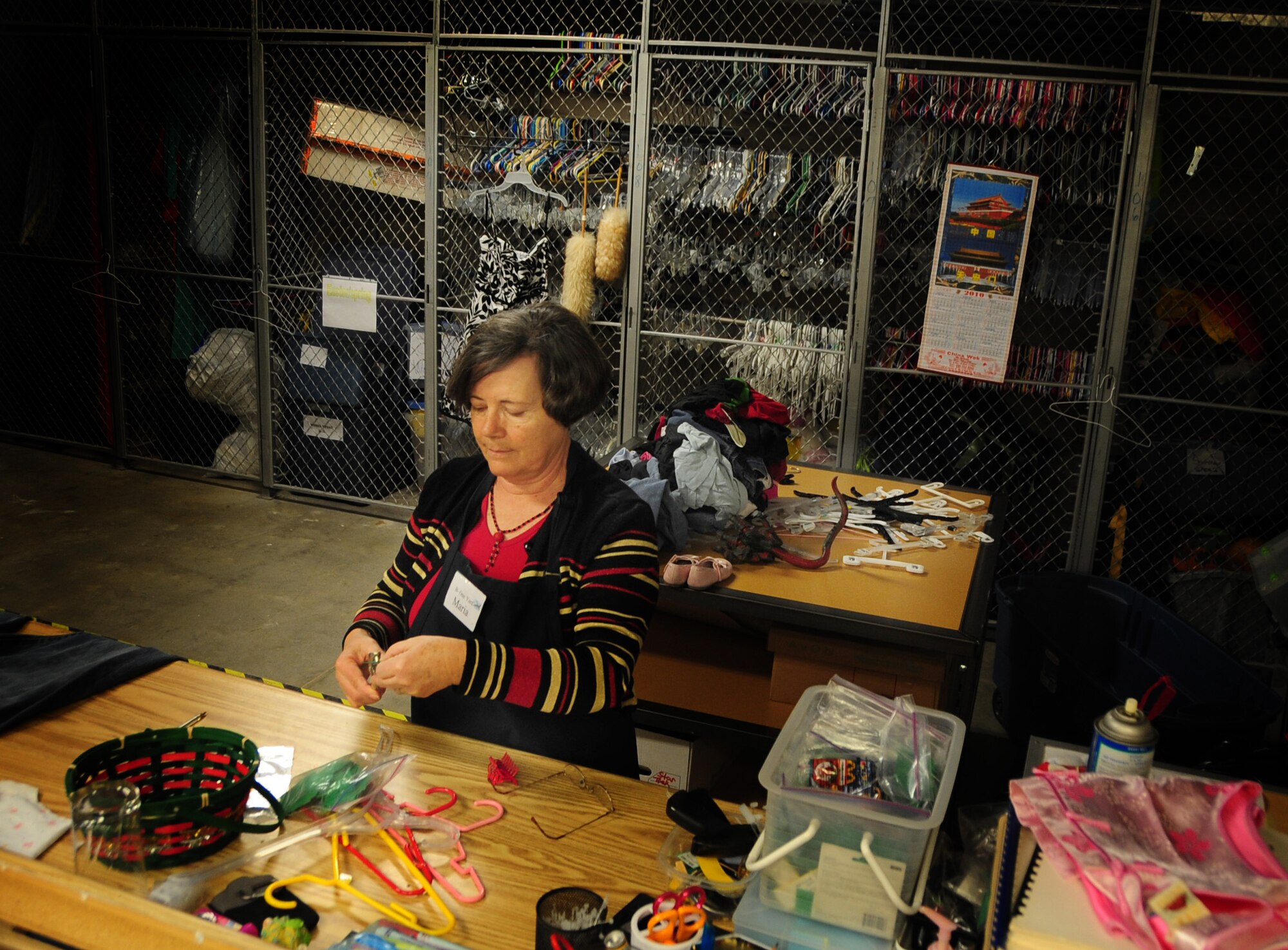 ELLSWORTH AIR FORCE BASE, S.D. -- Maria Gavle, a volunteer working at the B-One Yard Thrift store, attaches hangers and price tags to clothes, Dec. 16.  The thrift store not only provides Airmen and their families with functional clothing at reasonable prices, but they also donate any surplus items to organizations for struggling families in Rapid City S.D. (U.S. Air Force photo/Senior Airman Anthony Sanchelli)
