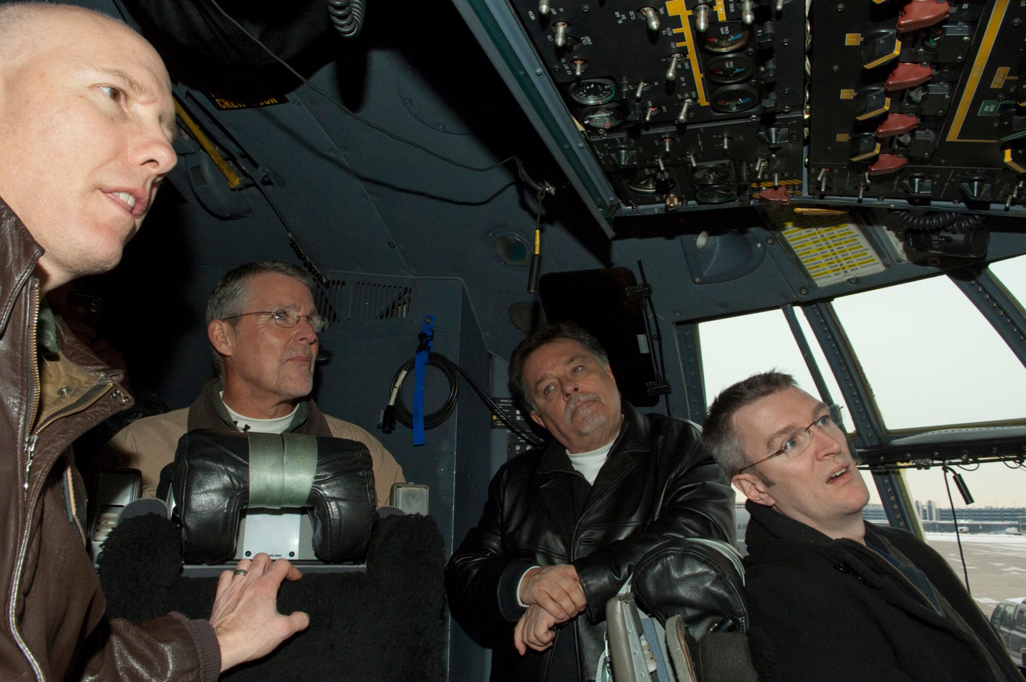 On the flight deck of a Minnesota Air National Guard C-130, Lt. Col. Dan Gabrielli, (left)  acting Vice Wing Commander and pilot in the 133rd Airlift Wing describes combat flying operations in a ?Hercules? military cargo aircraft to (moving right) George Liddle of LNC Marketing, Barry Ford, VP of Operations of Minnesota Hockey, and Dan Bennett of Thompson Reuters on Dec. 16, 2010 at the Minneapolis, St. Paul International Airport. The guests are all supporters of Defending the Blue Line, a non-profit organization that, along with the NHL Players Association, provides hockey playing opportunities for children of military members. USAF official photo by Senior Master Sgt. Mark Moss