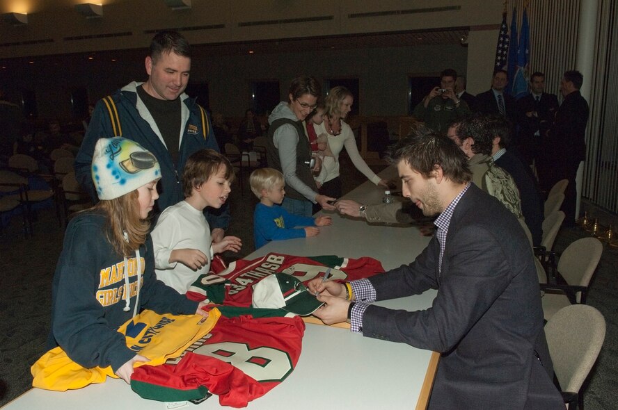 Brent Burns (right), defenseman for the Minnesota Wild, signs his autograph for military family members on Dec. 15, 2010 during a program featuring the Wild players at the 133rd Airlift Wing in St. Paul, Minn.  Many of the children benefited from the efforts of the players through organizations like the NHL Players Association and Defending the Blue Line, which links other organizations providing hockey equipment, camps and ice time. The players were honored by organizations such as the 934th Airlift Wing, USAF Reserve, Minnesota Army National Guard units, as well as the 133rd AW. USAF official photo by Senior Master Sgt. Mark Moss