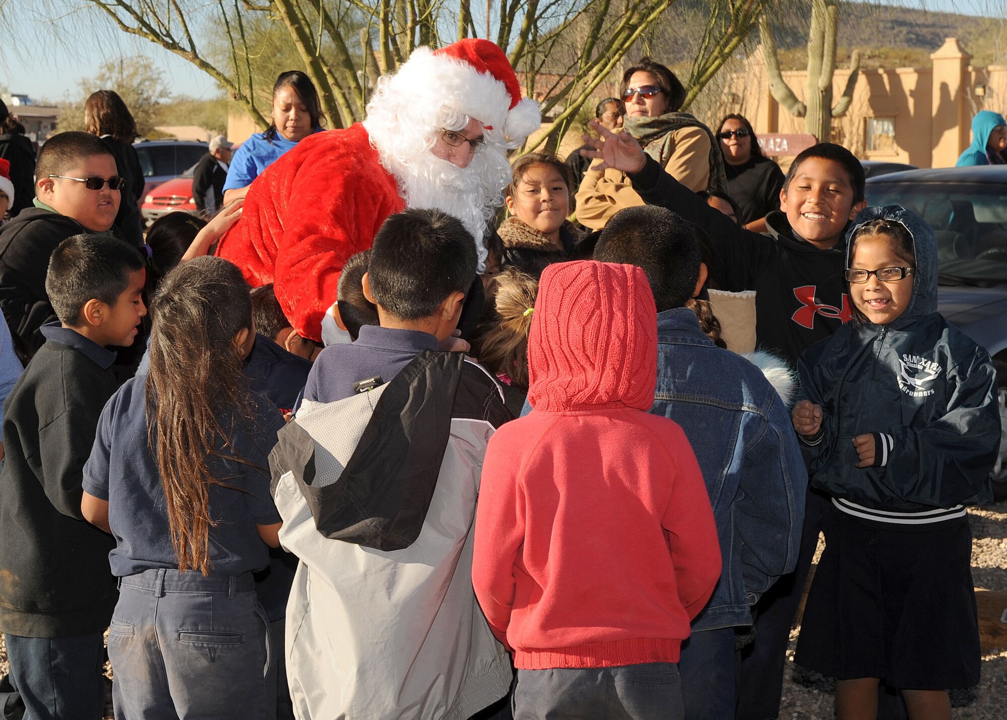 Master Sgt Cesar Medina, Santa, from the 612 Air Operation Center, is greeted with hugs from the children from San Xavier Mission School while visiting for Santa?s in Blue, December 9, 2010. There were approximately 180 children at San Xavier that received gifts from Santa. Davis-Monthan has travel to several schools to give kids from low income families gifts for Christmas since 1965. (U.S. Air Force photo/Senior Airman Brittany Dowdle) (RELEASED)