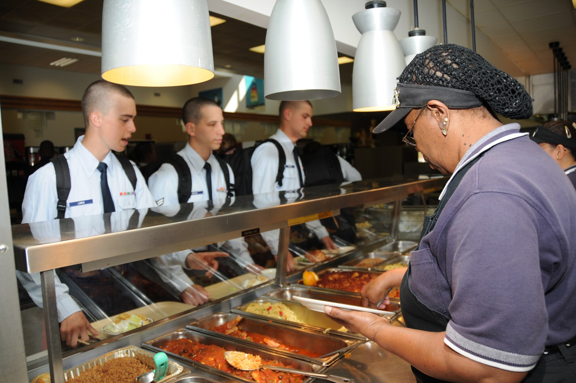 From left, Airman Basic Bernard Links, 332nd Training Squadron; Airman 1st Class David Gross, 336th TRS; and Airman Basic Robert Oberle, 338th TRS, are served lunch by Carrie Keeton at the Azalea Dining Facility. Keesler won the John L. Hennessy Award recognizing the Air Force’s top food service operation. The base’s three dining facilities serve about 2.4 million meals annually.  (U.S. Air Force photo by Kemberly Groue)