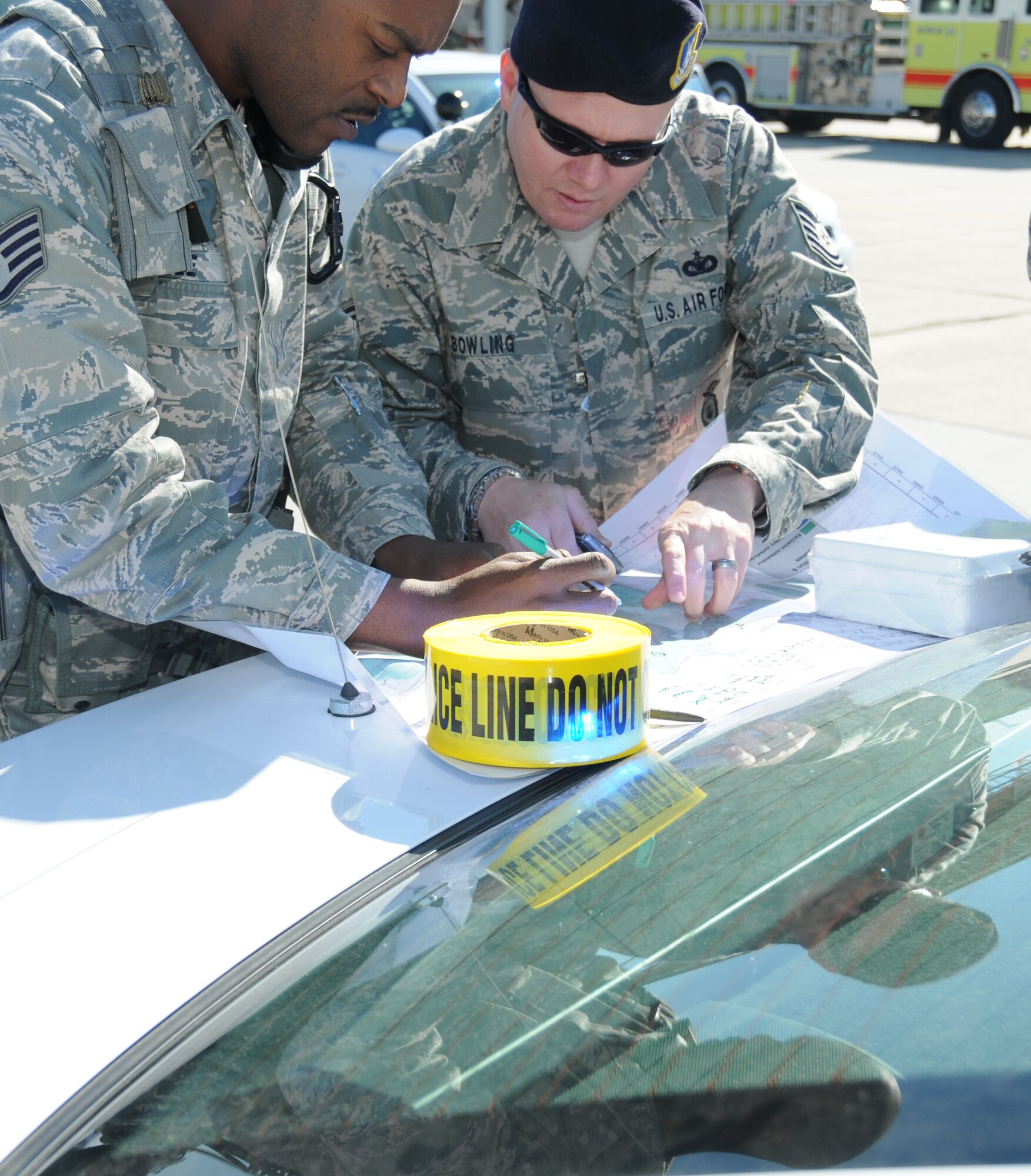 Staff Sgt. Teddy Poole, left, and Tech. Sgt. Christopher Bowling, 81st Security Forces Squadron, discuss an action plan and cordon placement on the flightline.  (U.S. Air Force photo by Kemberly Groue)