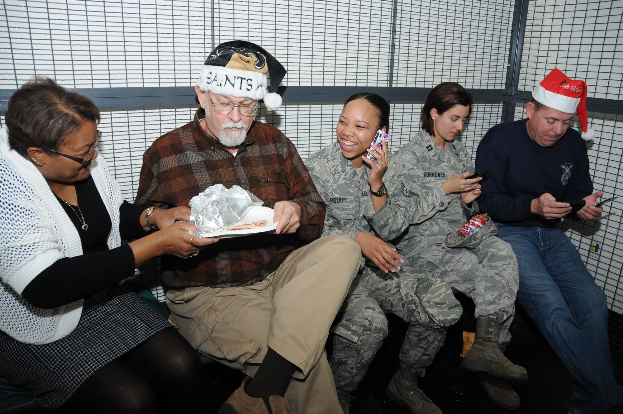 From left, Francis Frye, 81st Security Forces Squadron; Carl Nehlig, 81st Training
Support Squadron; Staff Sgt. Merissa Pough, 81st Training Wing; Capt. Donna
Burroughs, 81st Medical Support Squadron; and Master Sgt. Christopher Rash, 81st
SFS, show no remorse as they laugh, eat and text while incarcerated as part of last
week’s Santa Police fundraiser.  (U.S. Air Force photo by Kemberly Groue)